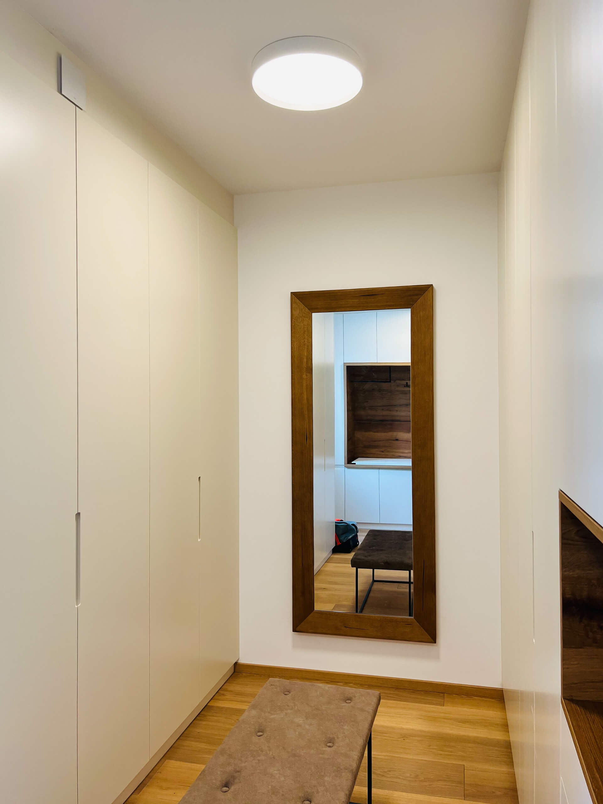 Flur mit Einbauschränken, Spiegel und Sitzbank – Lichtplanung von Illumina.