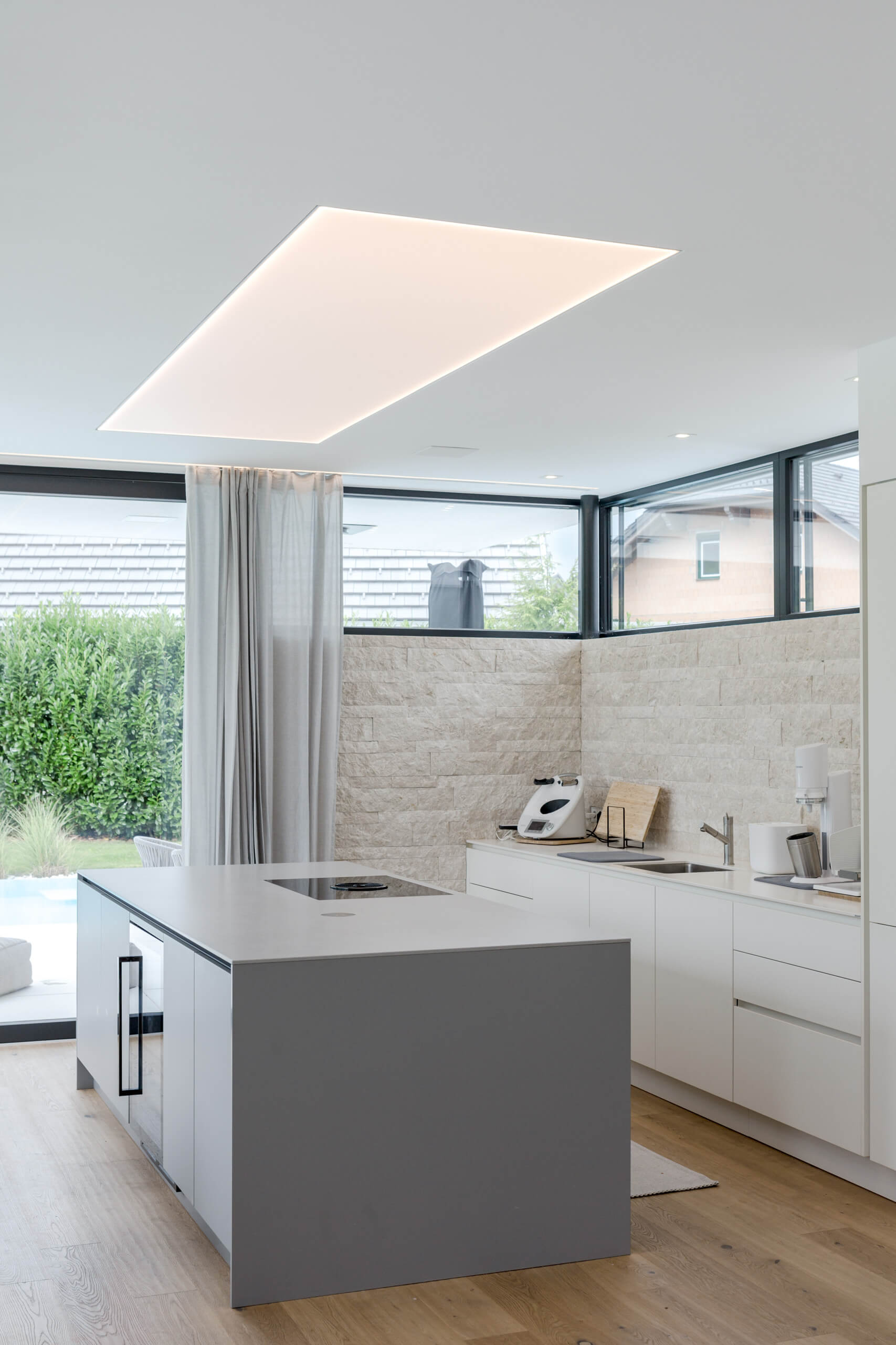 Moderne Küche mit Kochinsel und integrierter Beleuchtung – Lichtplanung von Illumina.