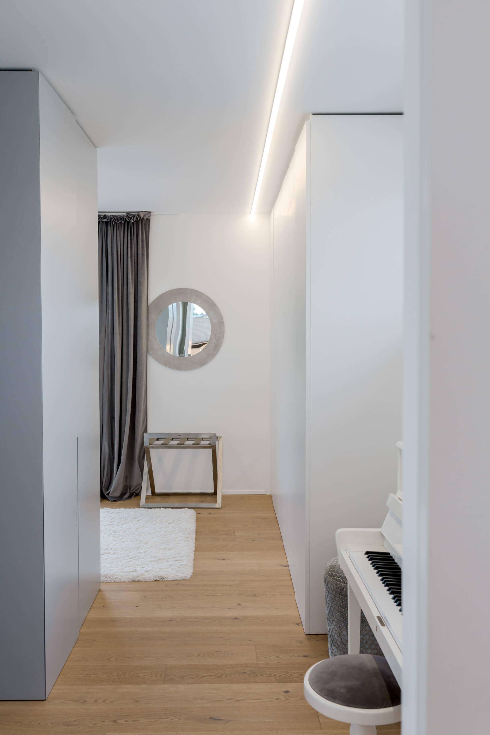Helle Diele mit Spiegel, Garderobe und Klavier – Lichtplanung von Illumina.