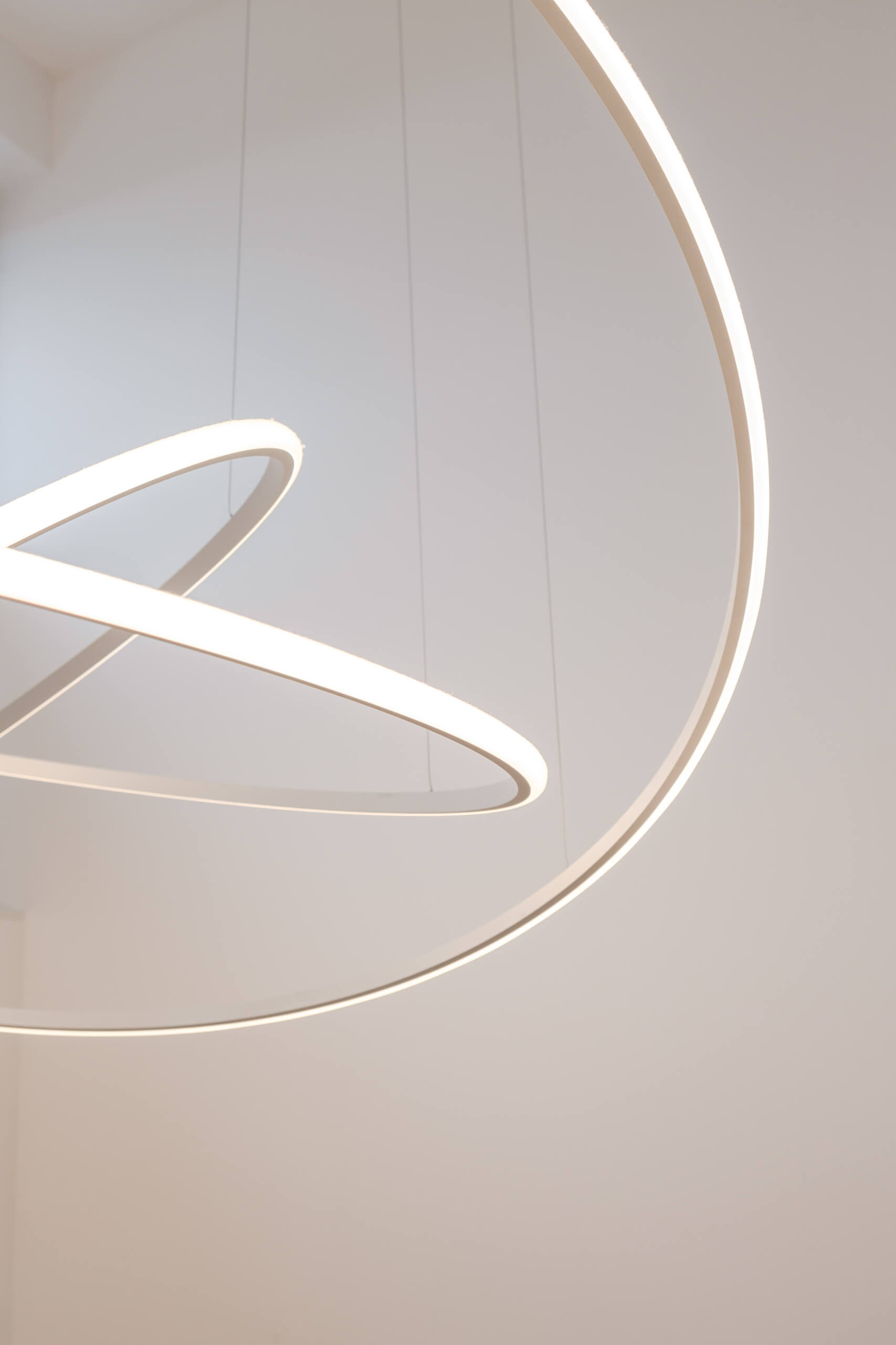Moderne Ring-Pendelleuchte mit indirekter Beleuchtung, die ein warmes Licht in den Raum wirft.