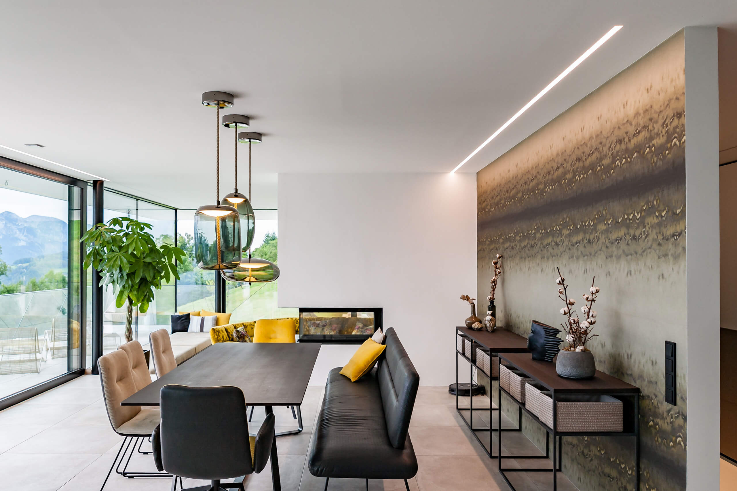 Modernes Esszimmer mit Kamin und Hängeleuchten – Lichtplanung von Illumina.
