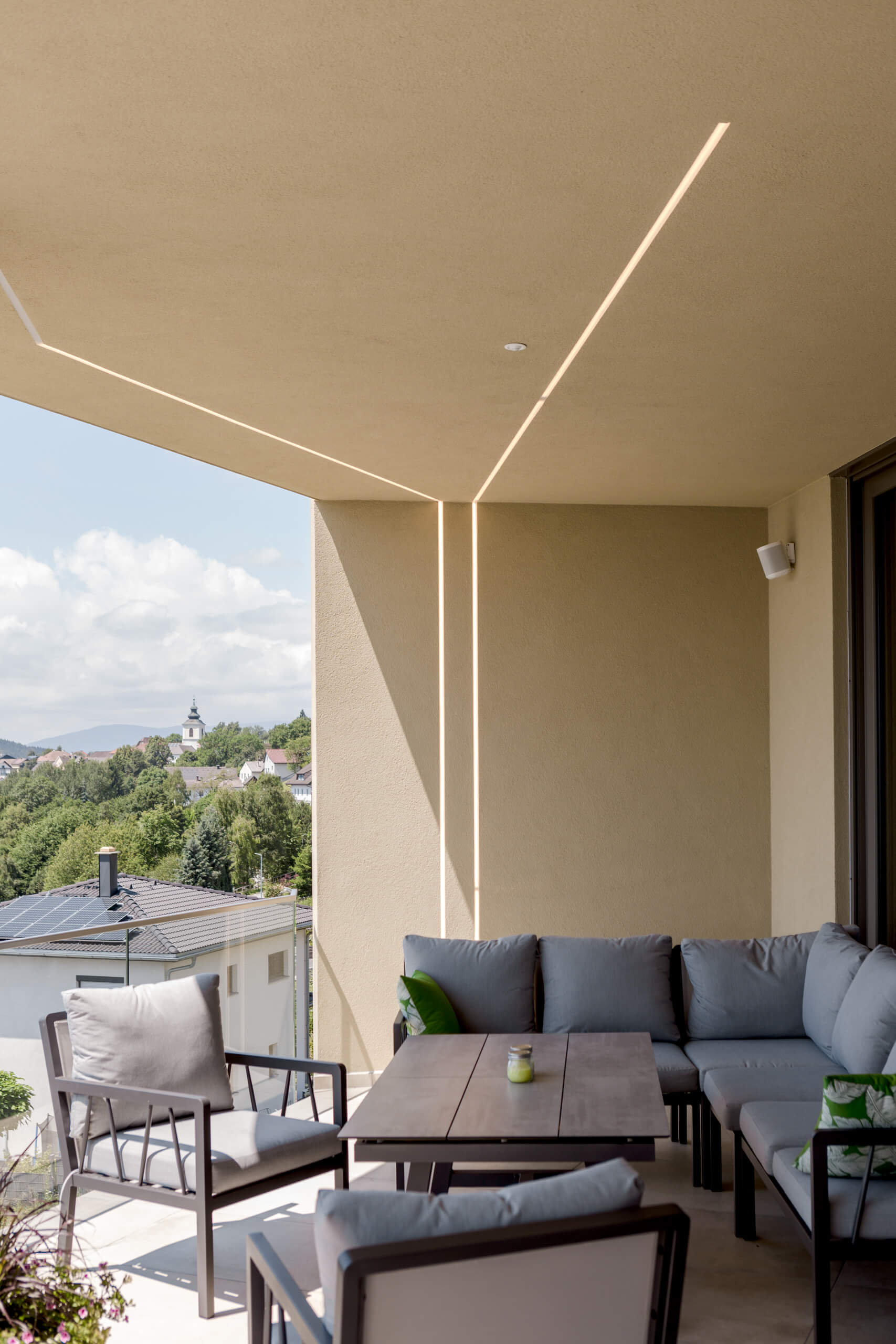 Moderne Balkonmöbel unter indirekter Beleuchtung mit Blick ins Grüne