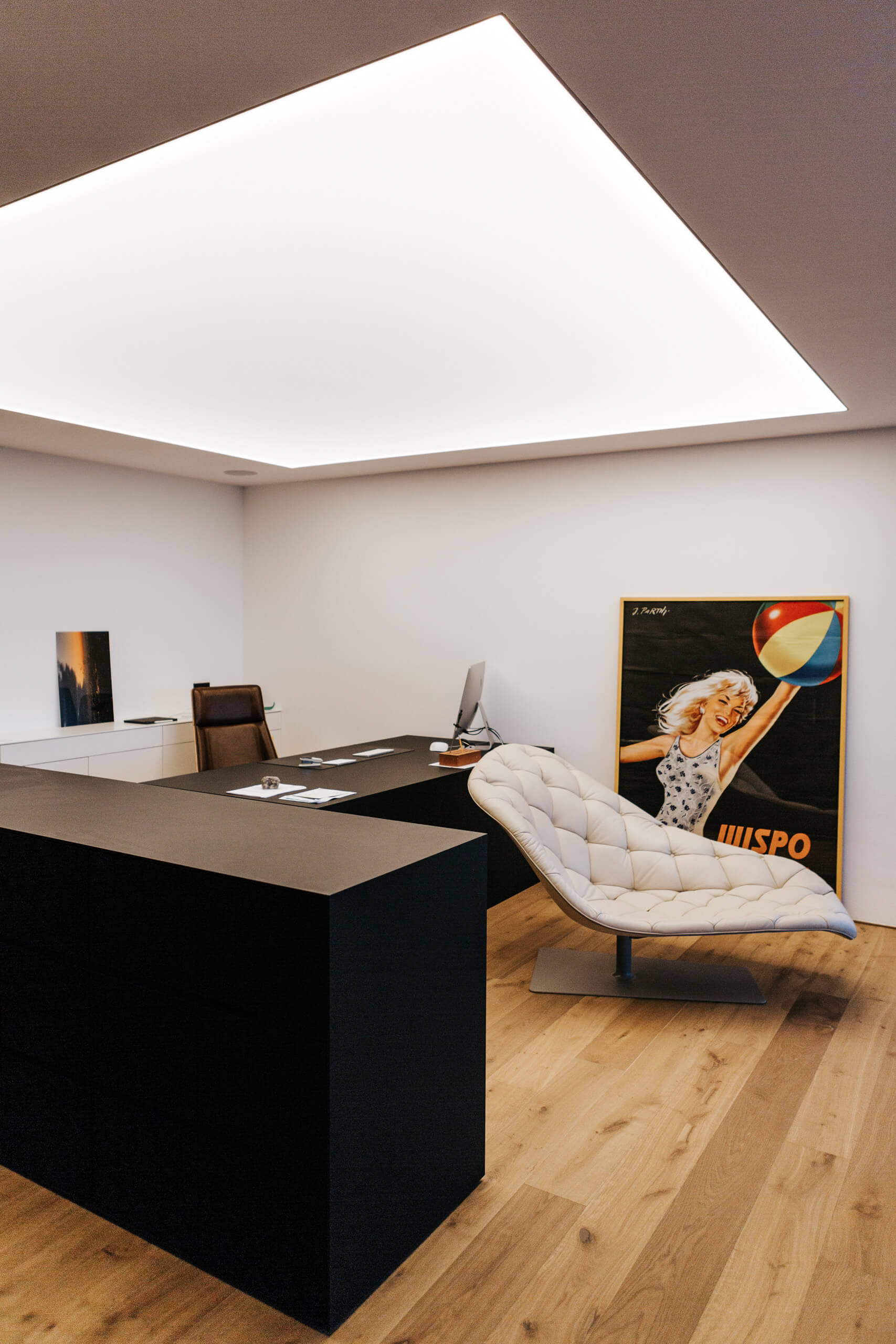 Modernes Büro mit schwarzem Empfangstresen, Ledersessel und Pop-Art-Poster.