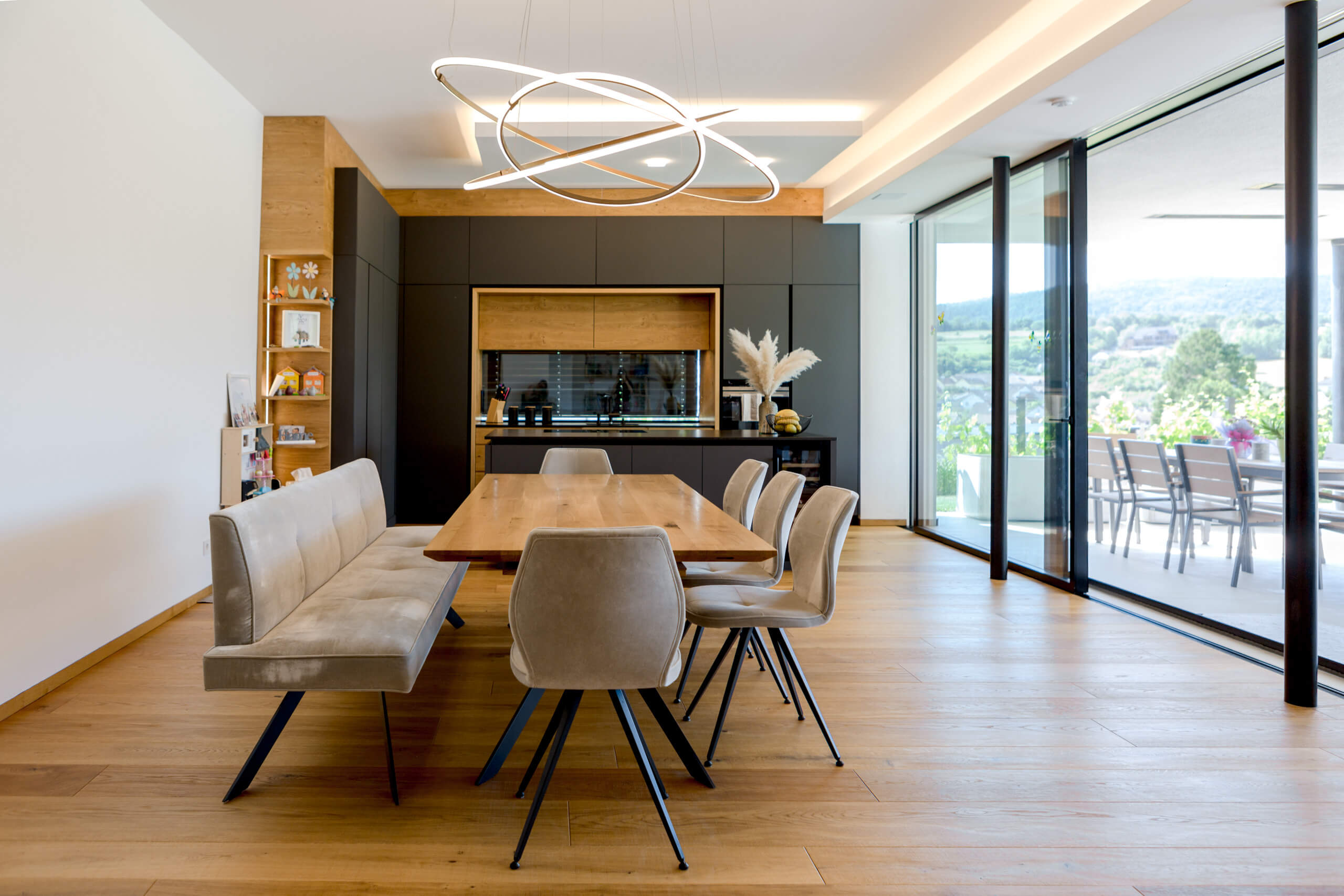 Moderne Wohnküche mit Essbereich und Hängeleuchte – Lichtplanung von Illumina.