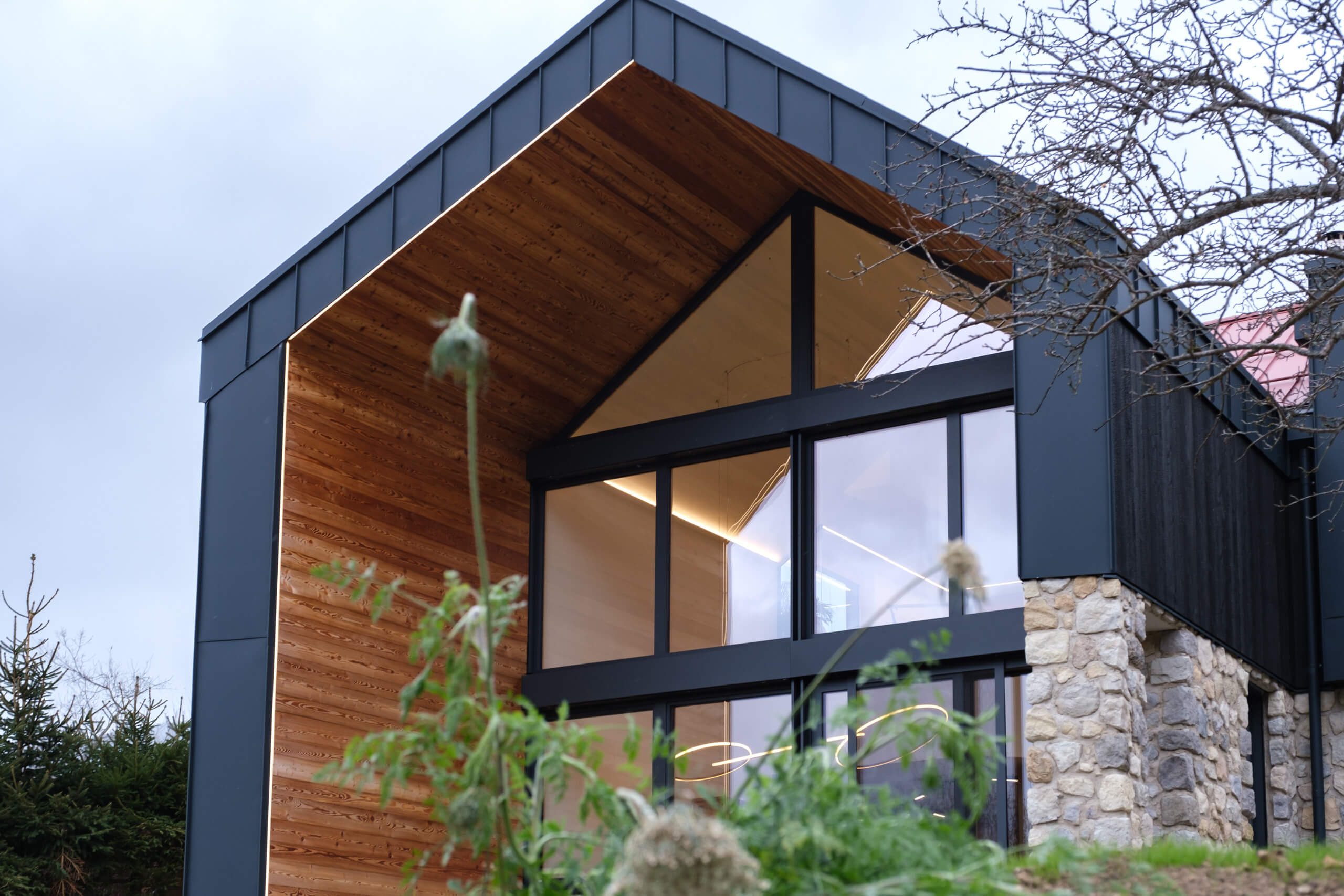 Moderne Architektur mit Holzakzenten und großflächigen Fenstern