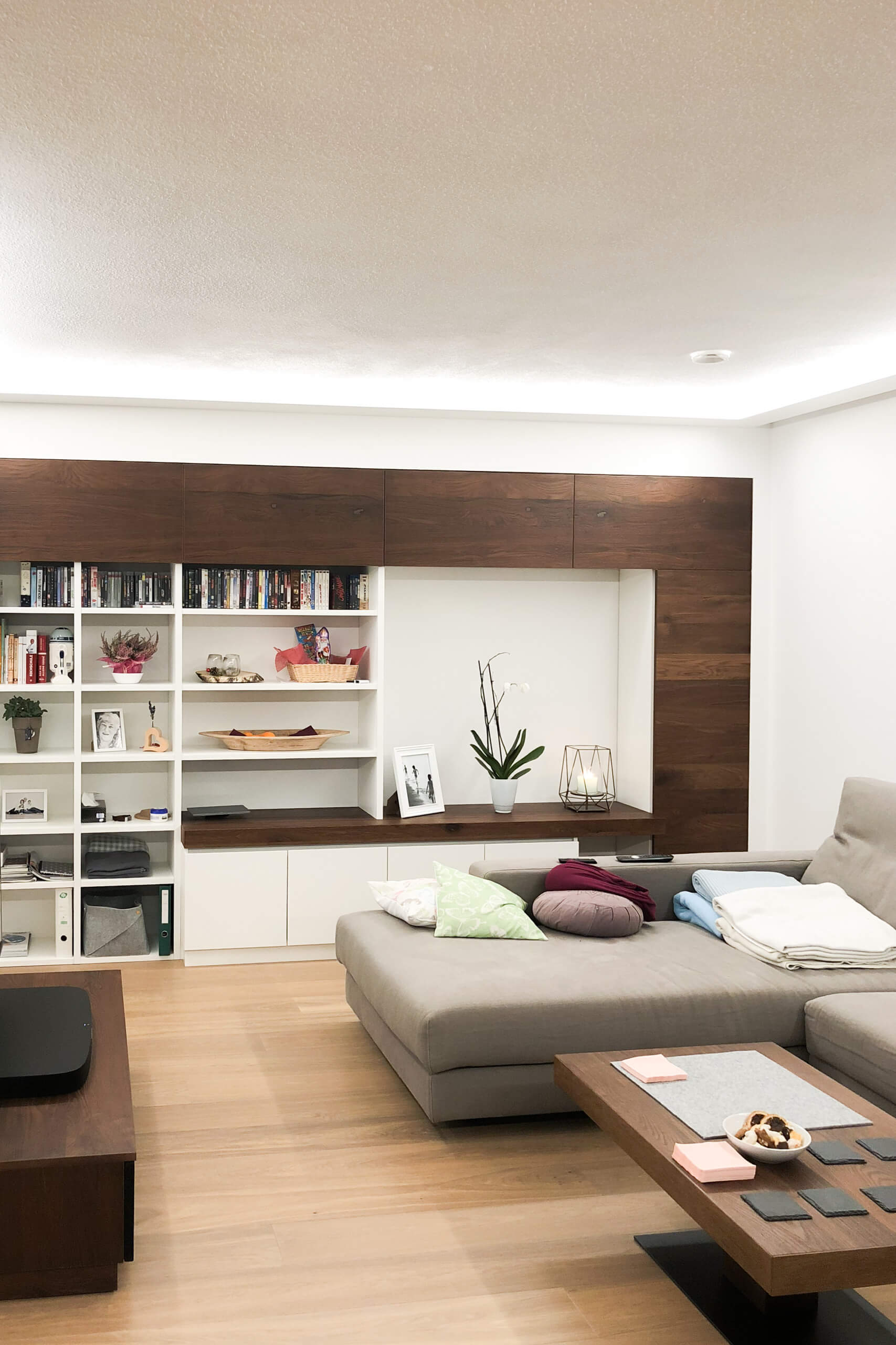 Modernes Wohnzimmer mit großzügiger Wohnwand und Ecksofa – Lichtplanung von Illumina.