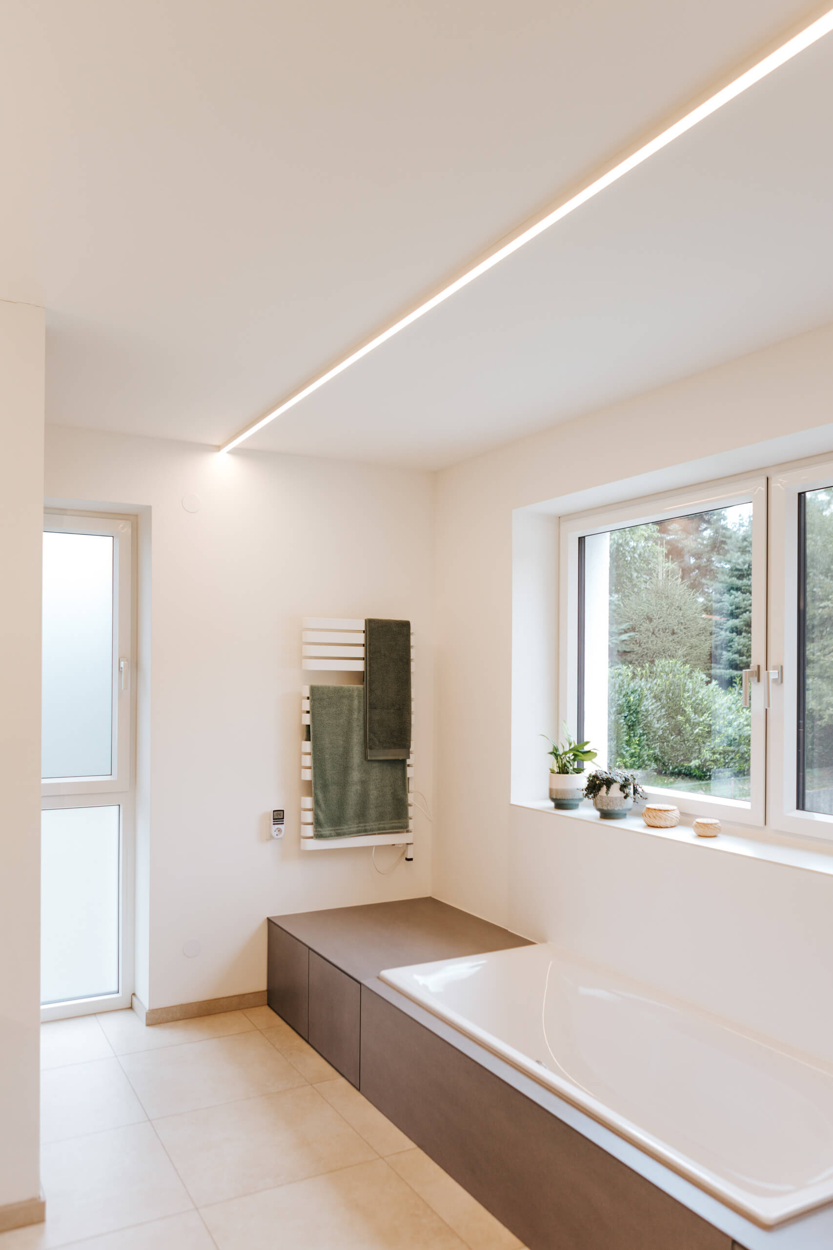 Modernes Badezimmer mit Badewanne und integrierter LED-Beleuchtung.