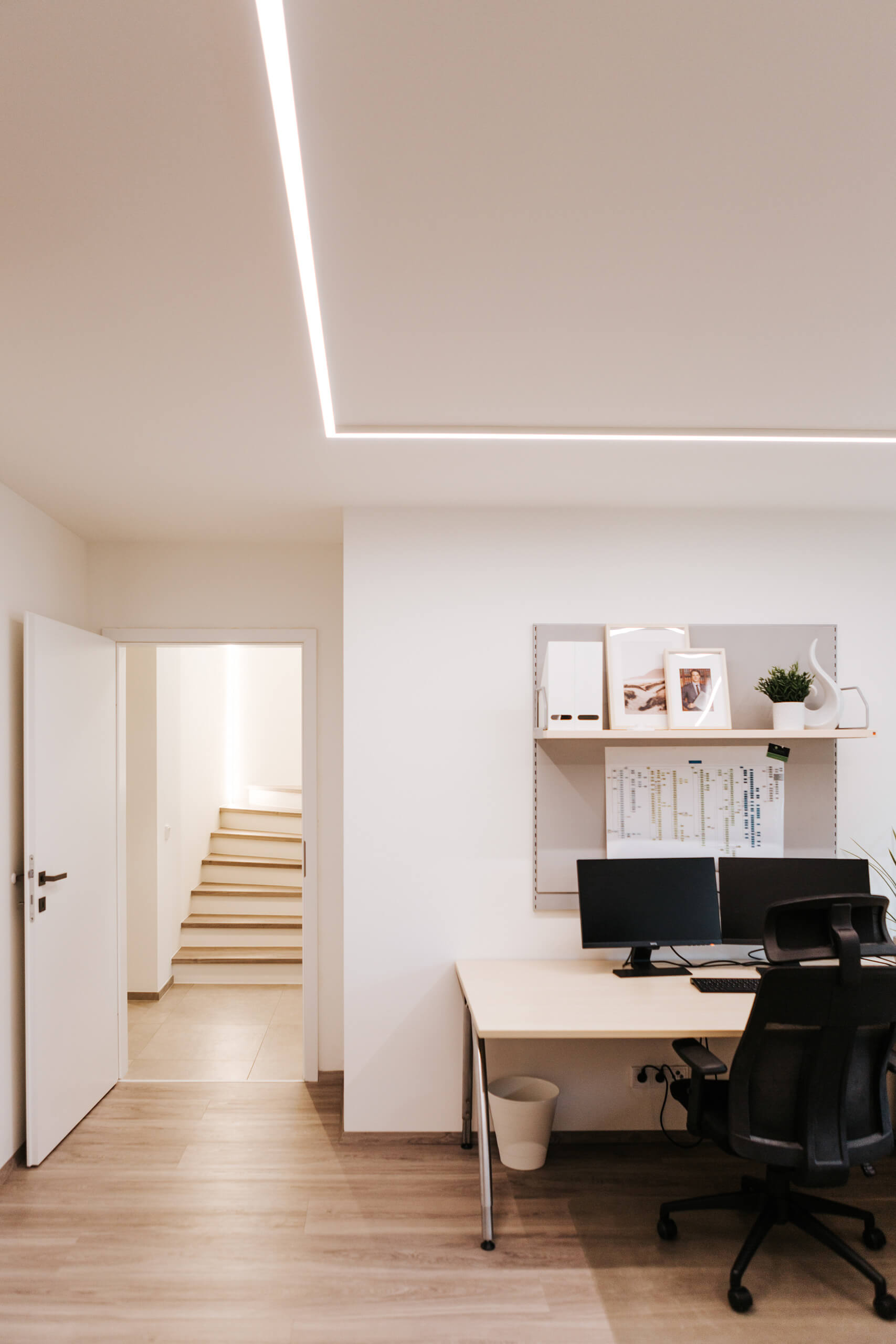 Modernes Büro mit heller Deckenbeleuchtung und Arbeitsplatz