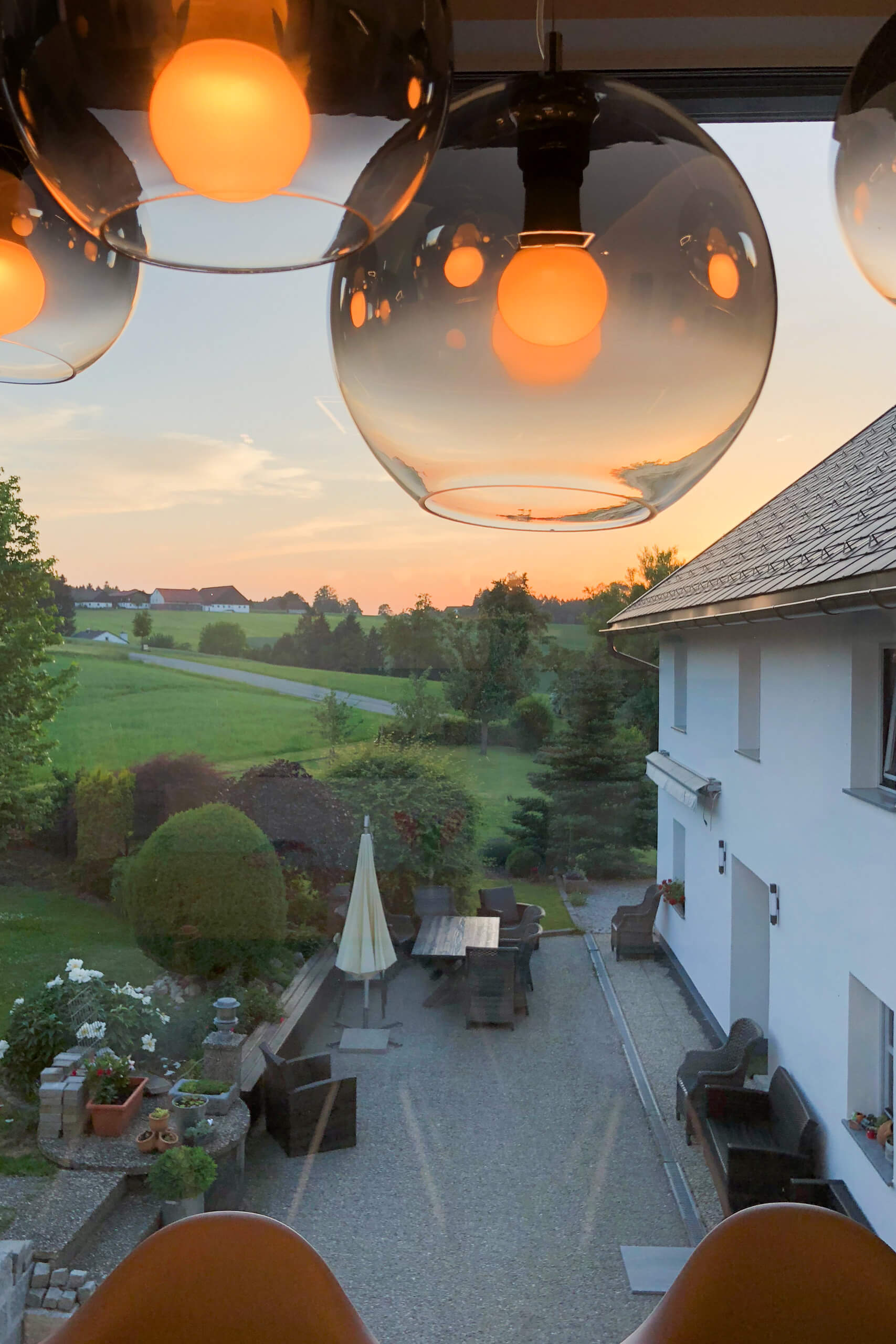 Gemütliche Terrasse mit Beleuchtung und Blick auf Sonnenuntergang – Lichtplanung von Illumina.