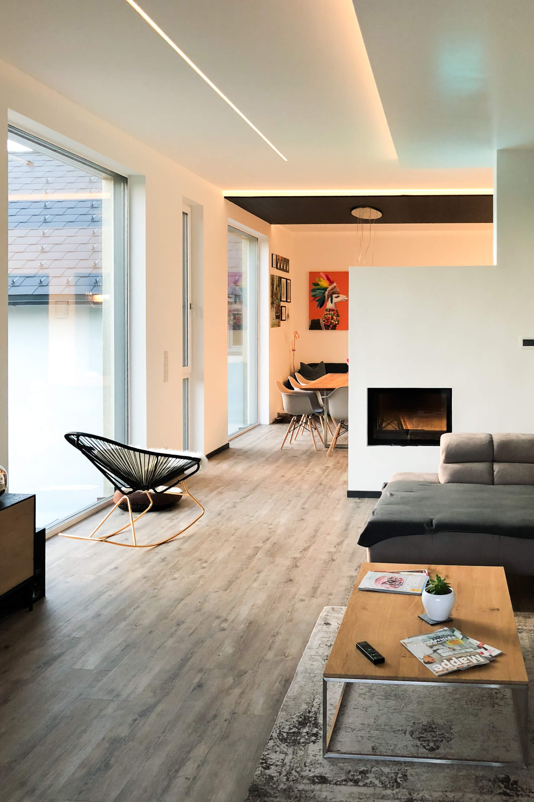 Modernes Wohnzimmer mit Kamin und indirekter Beleuchtung – Lichtplanung von Illumina