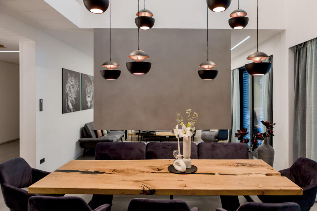 Modernes Esszimmer mit rustikalem Holztisch, Samtstühlen und stilvollen Pendelleuchten