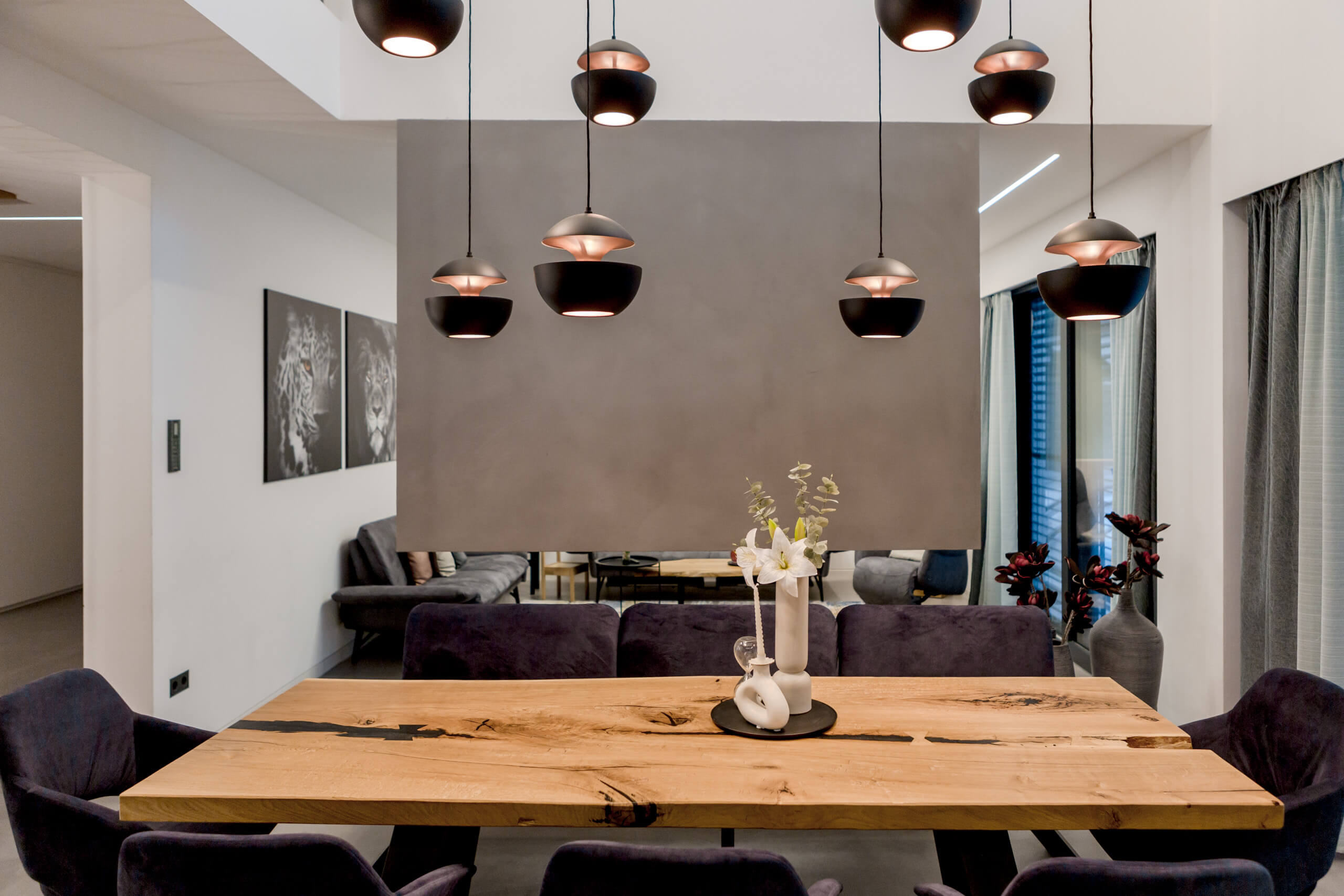 Modernes Esszimmer mit rustikalem Holztisch, Samtstühlen und stilvollen Pendelleuchten
