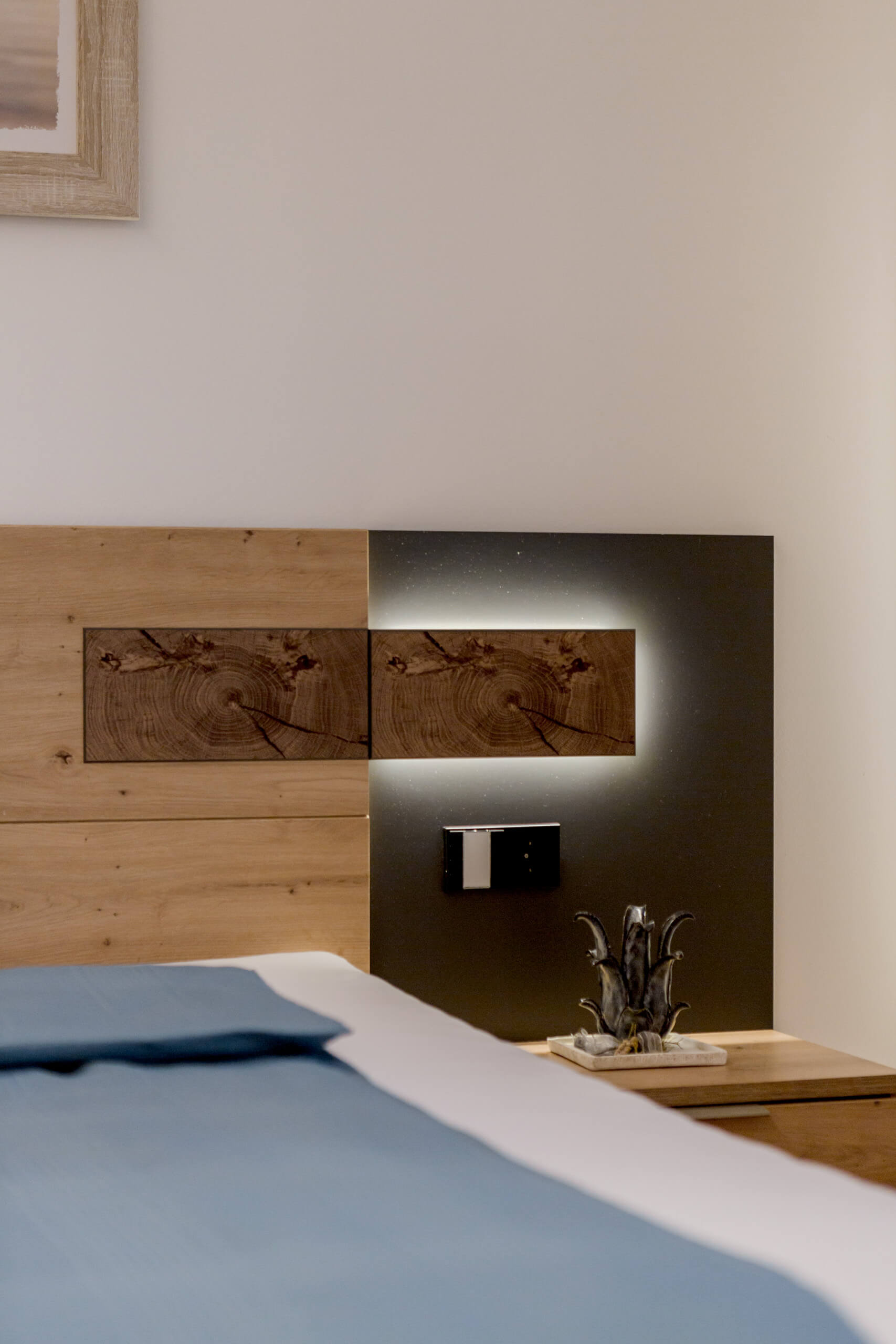 Modernes Schlafzimmer mit indirekter Beleuchtung und Holz-Kopfteil – Lichtplanung von Illumina.
