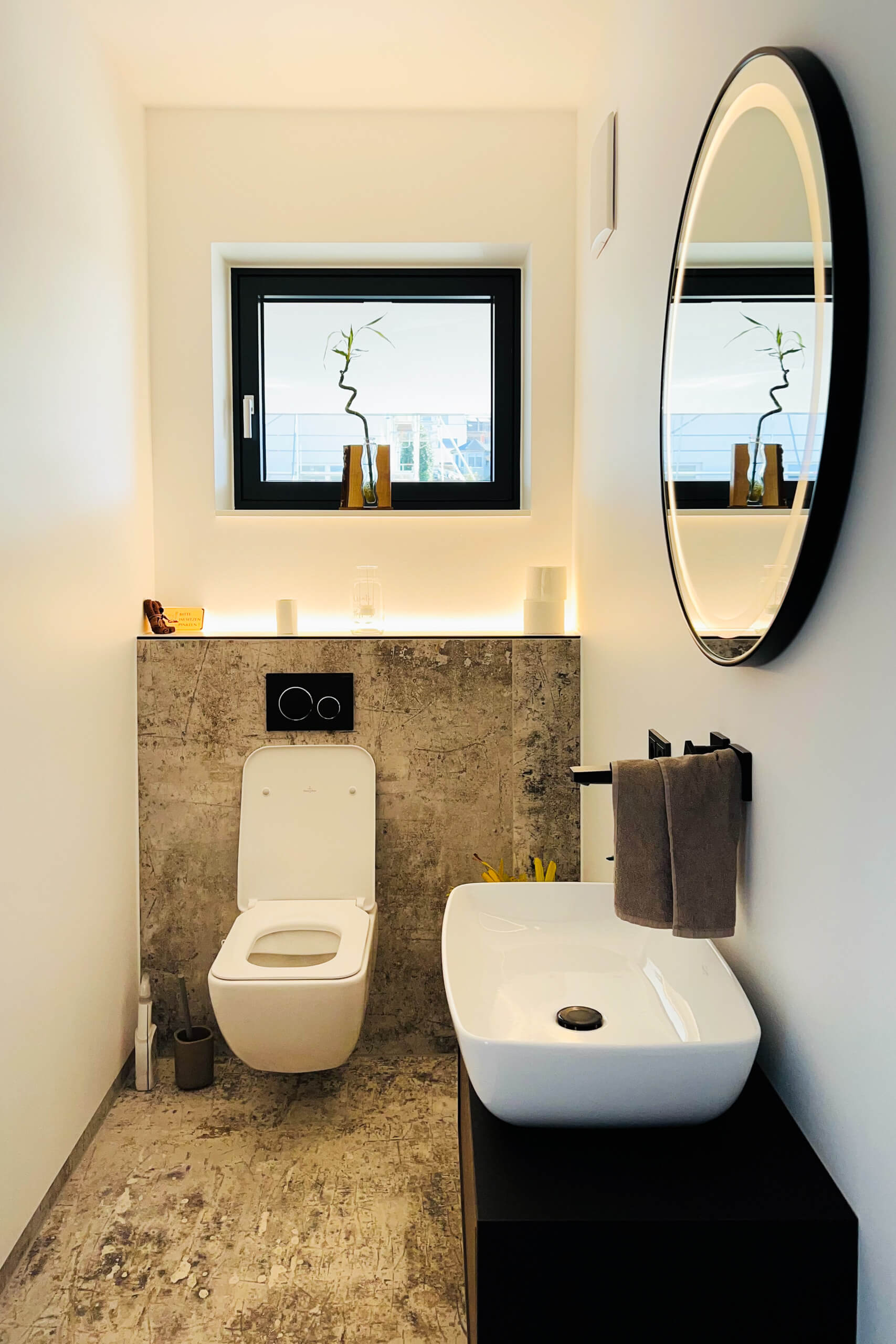 Modernes Badezimmer mit Waschtisch und WC, stimmungsvoll beleuchtet
