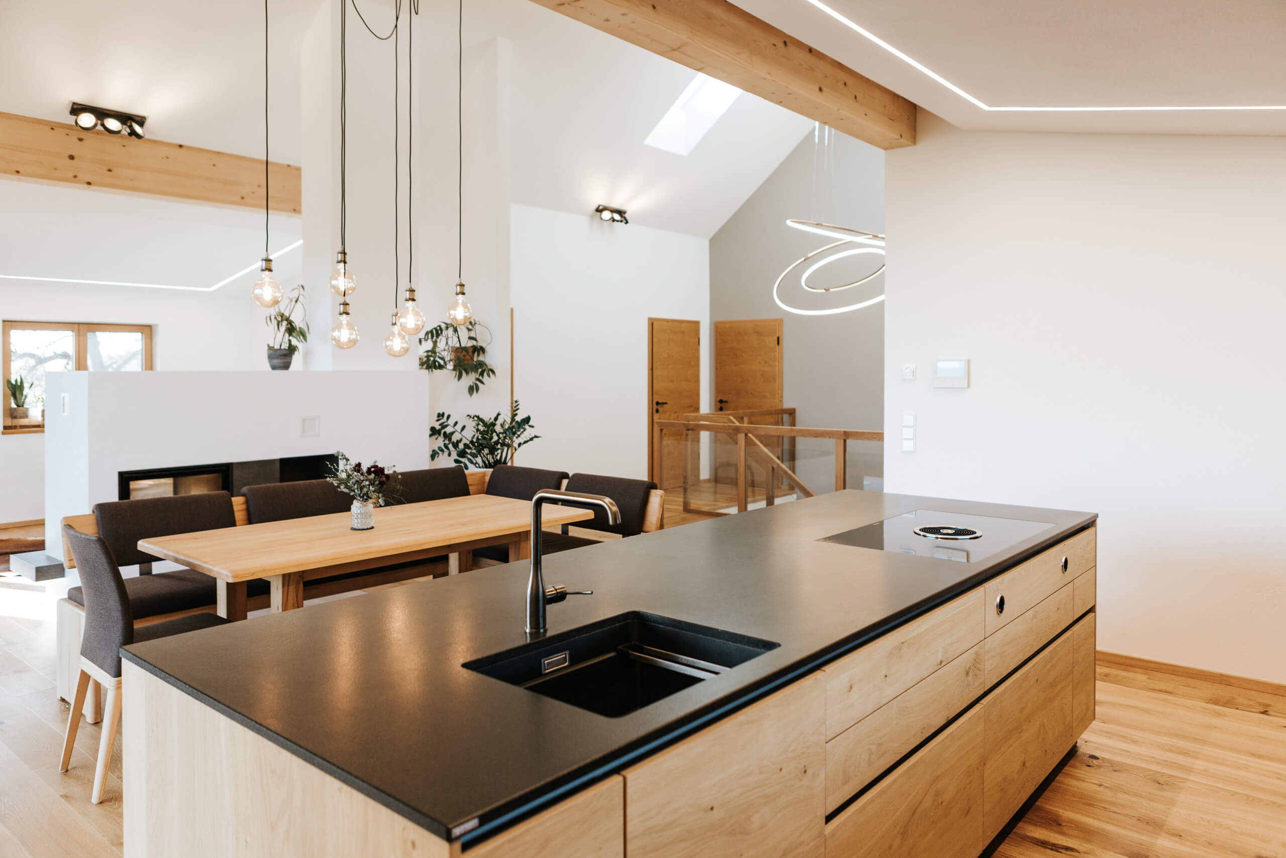 Moderne Küche mit Kochinsel, Essbereich und Kamin – Lichtplanung von Illumina
