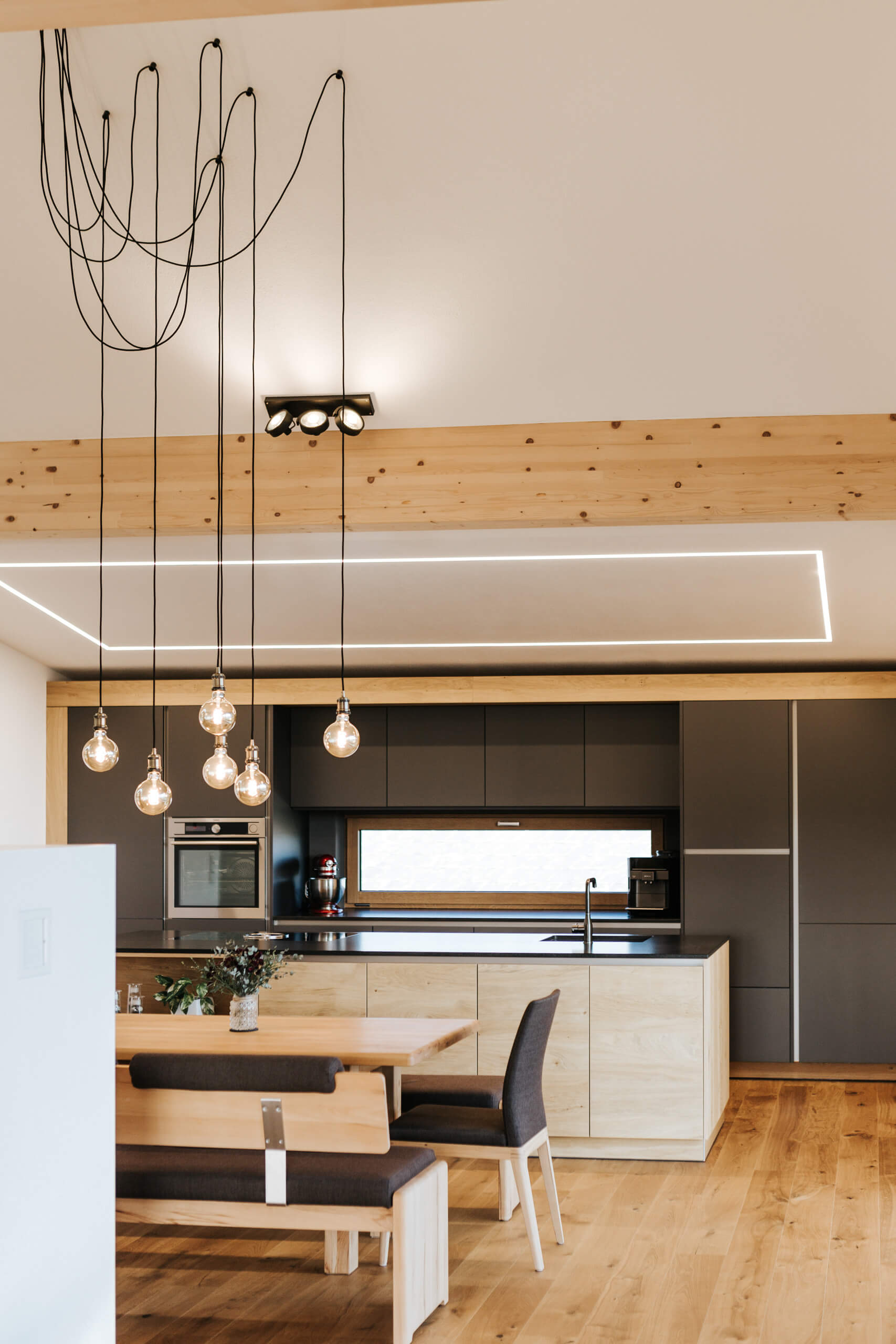 Moderne Küche mit Essbereich und Pendelleuchten – Lichtplanung von Illumina.