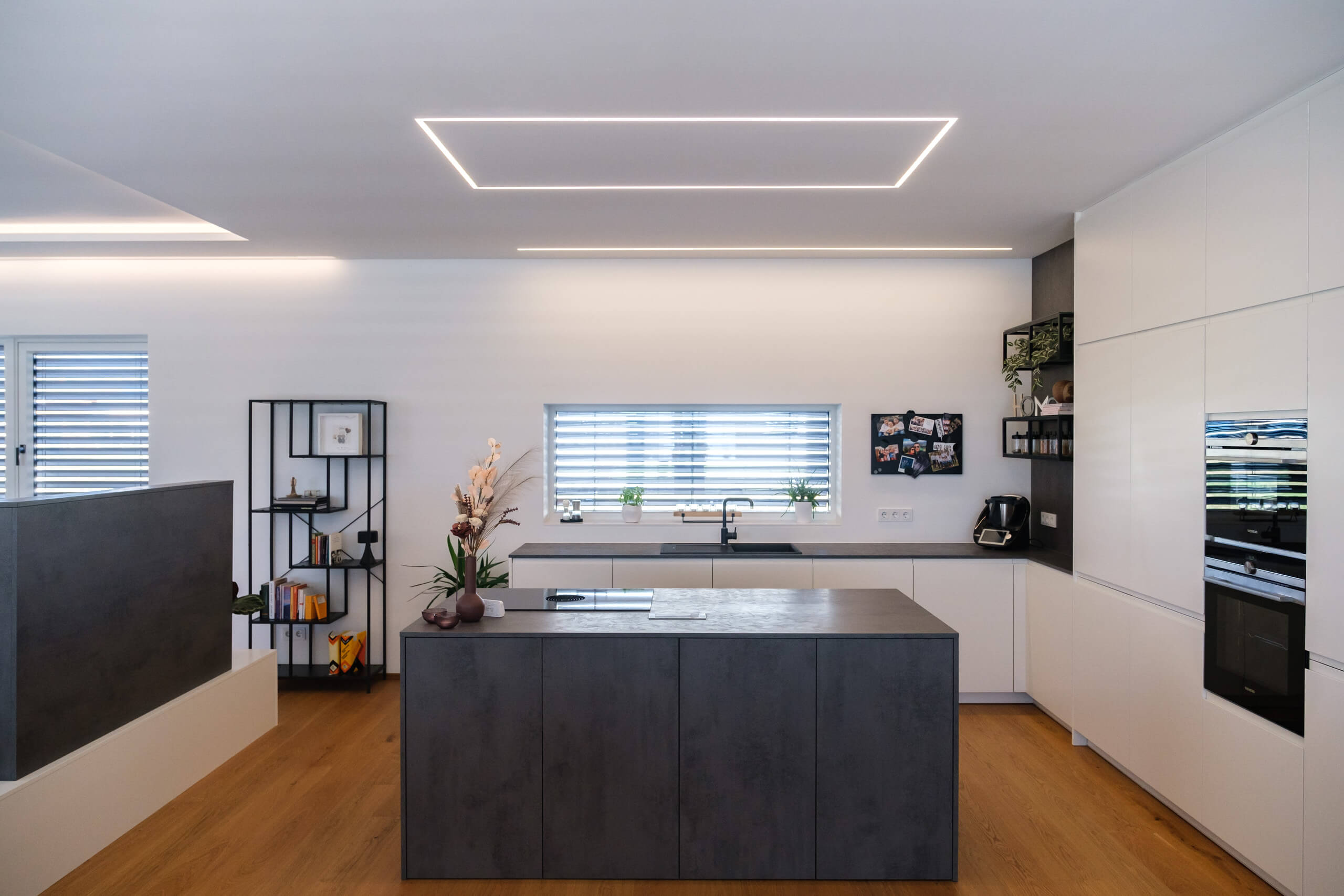 Moderne Küche mit Kochinsel, integriertem Lichtband und stilvoller Beleuchtung – Lichtplanung von Illumina.