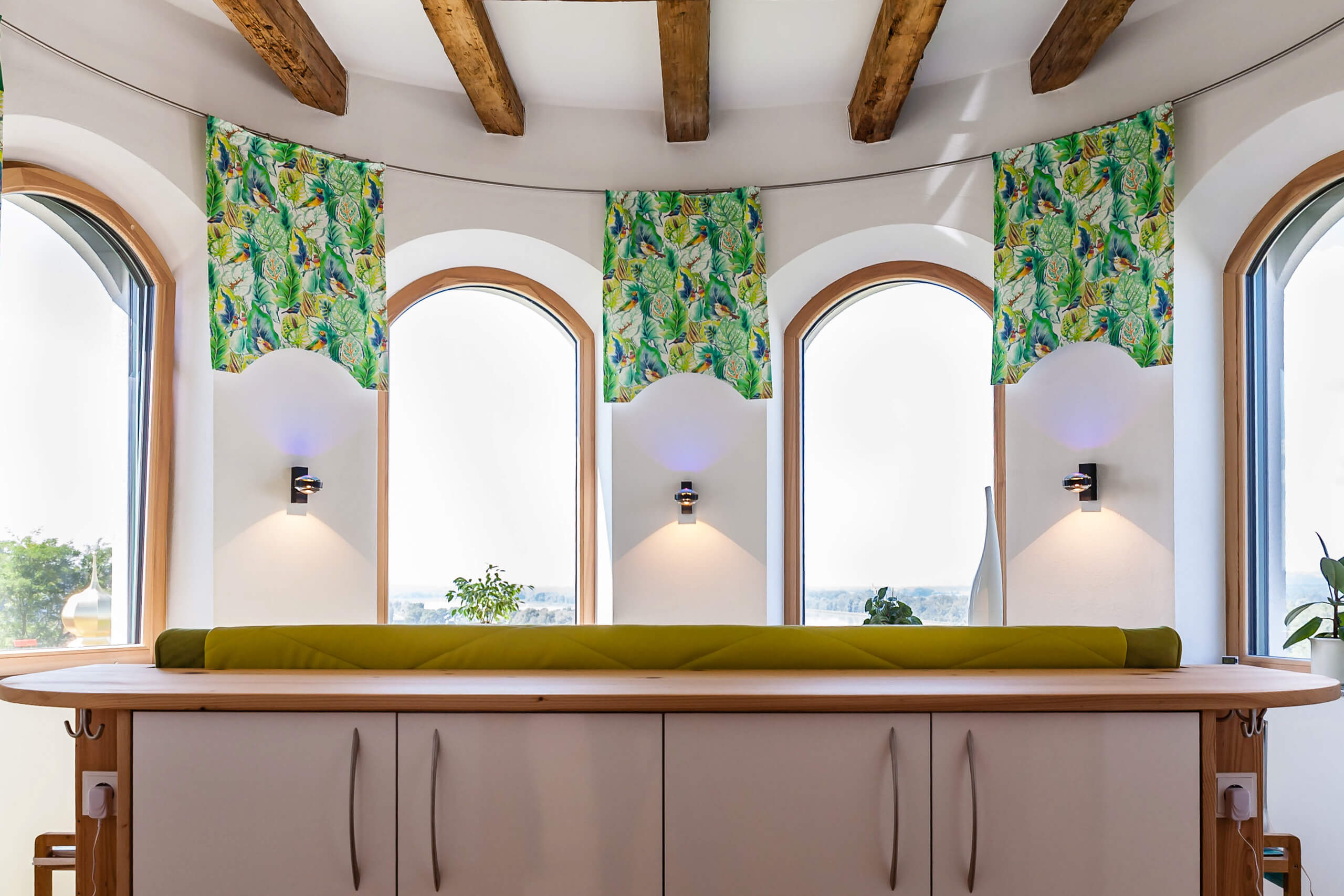 Helle Fensterfront mit bunten Vorhängen und Sitzbank – Lichtplanung von Illumina