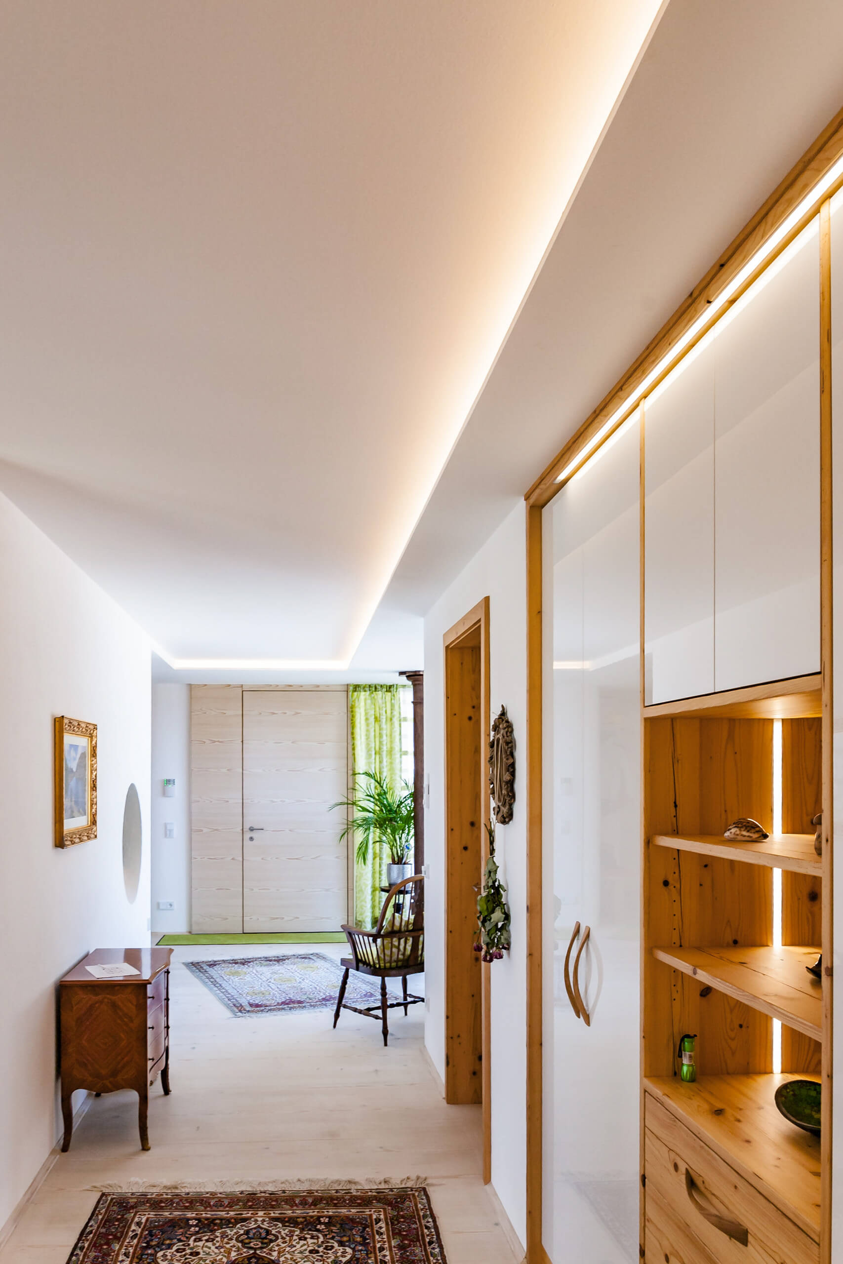 Beleuchteter Flur mit Holzeinbauten und Teppichen – Lichtplanung von Illumina