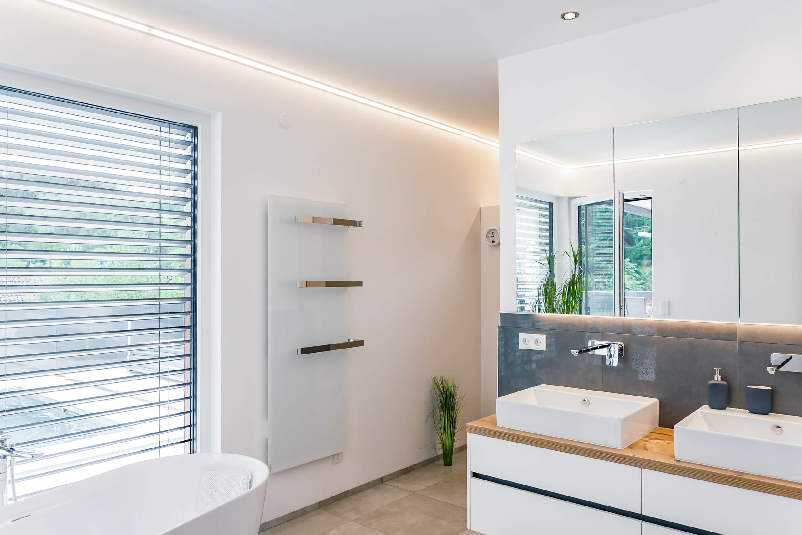 Modernes Badezimmer mit Doppelwaschtisch und Badewanne, stimmungsvoll beleuchtet