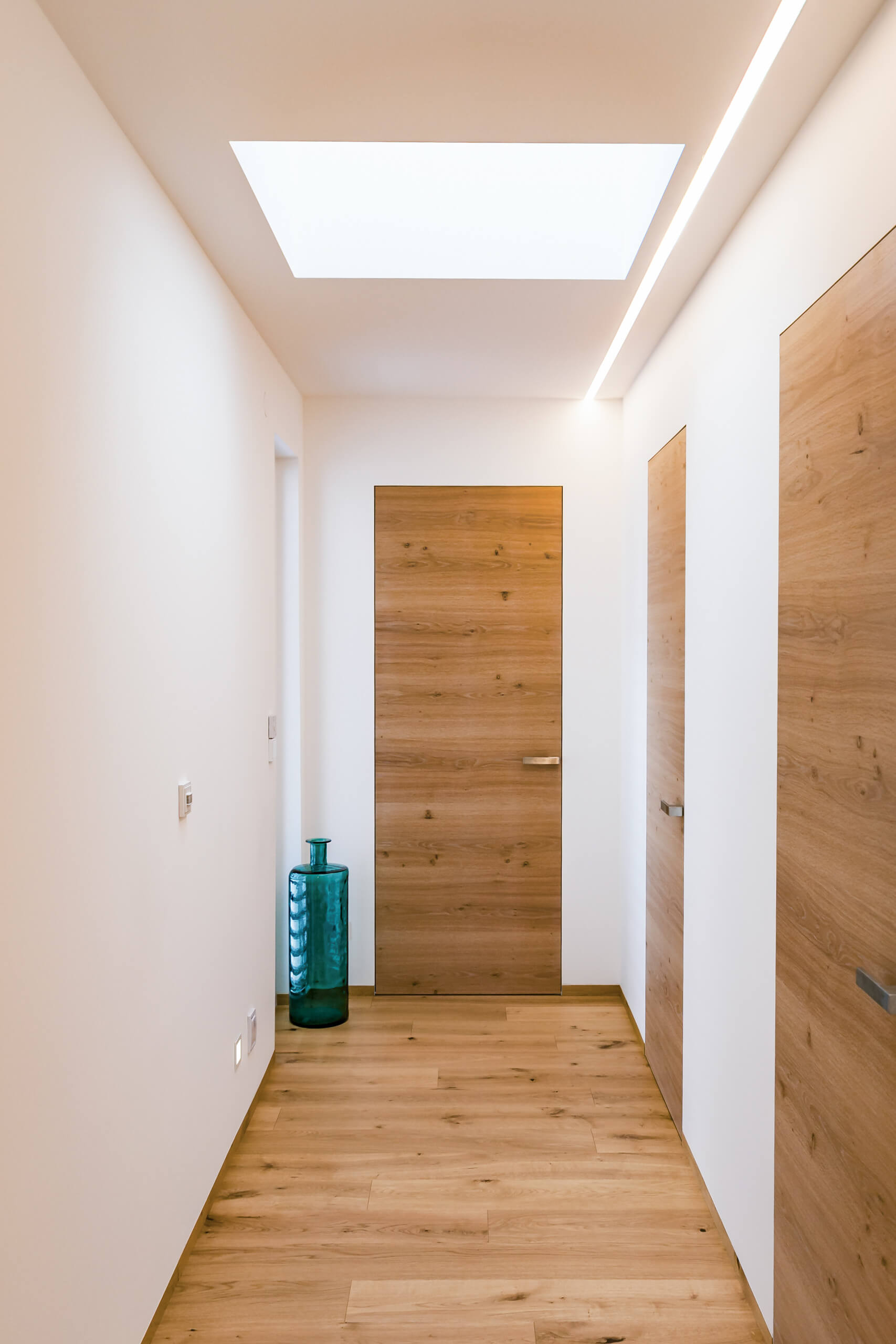 Moderner Flur mit Holztüren und Oberlicht – Lichtplanung von Illumina