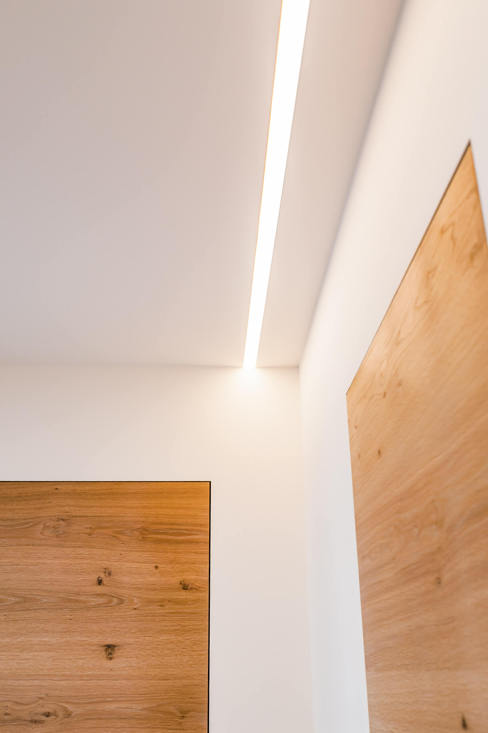 Moderne Deckenbeleuchtung mit Holzdetails in einem hellen Raum.