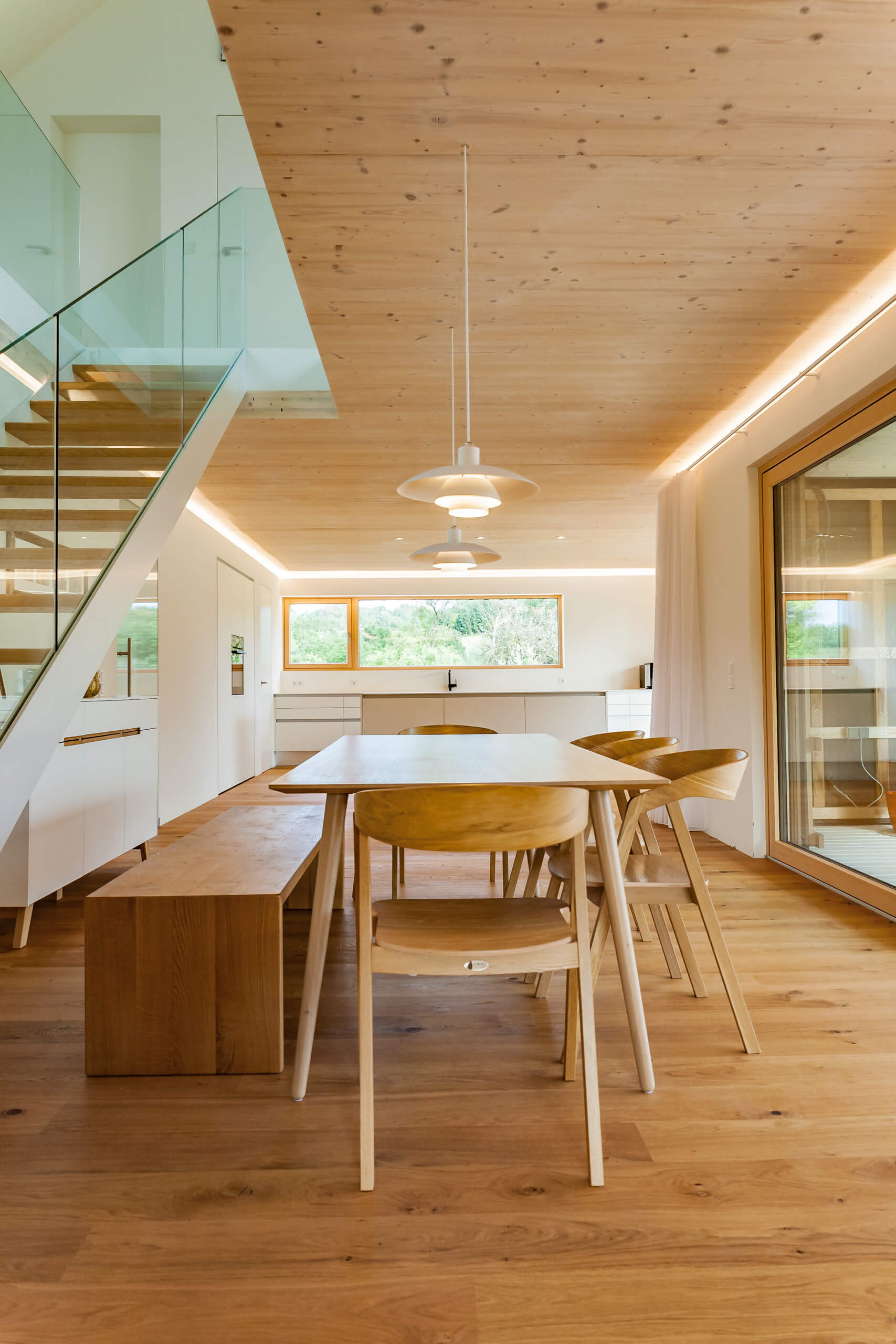 Moderne Essküche mit Holzboden und Deckenbeleuchtung – Lichtplanung von Illumina.