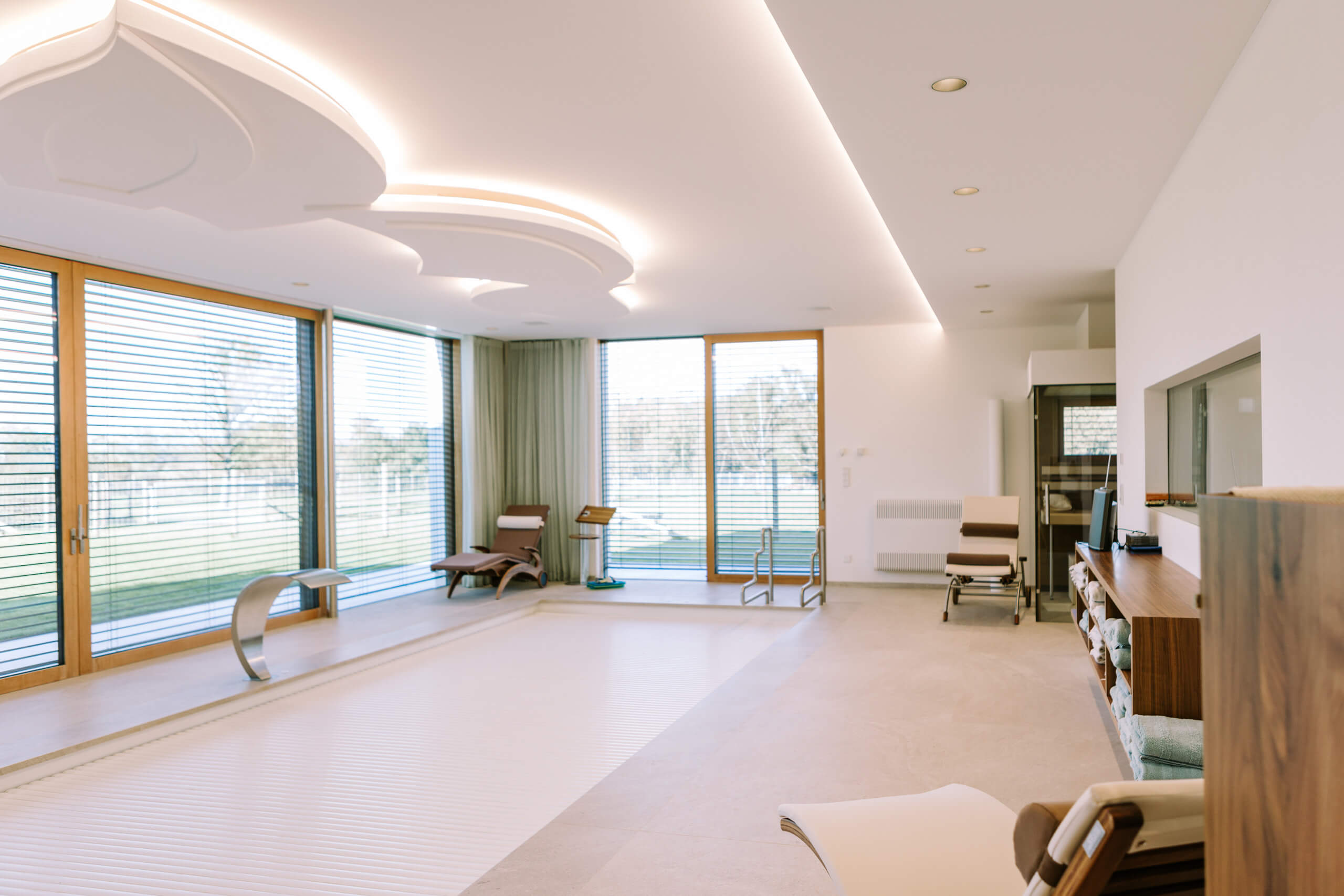 Hallenbad mit modernem Lichtdesign und Poolabdeckung – Lichtplanung von Illumina