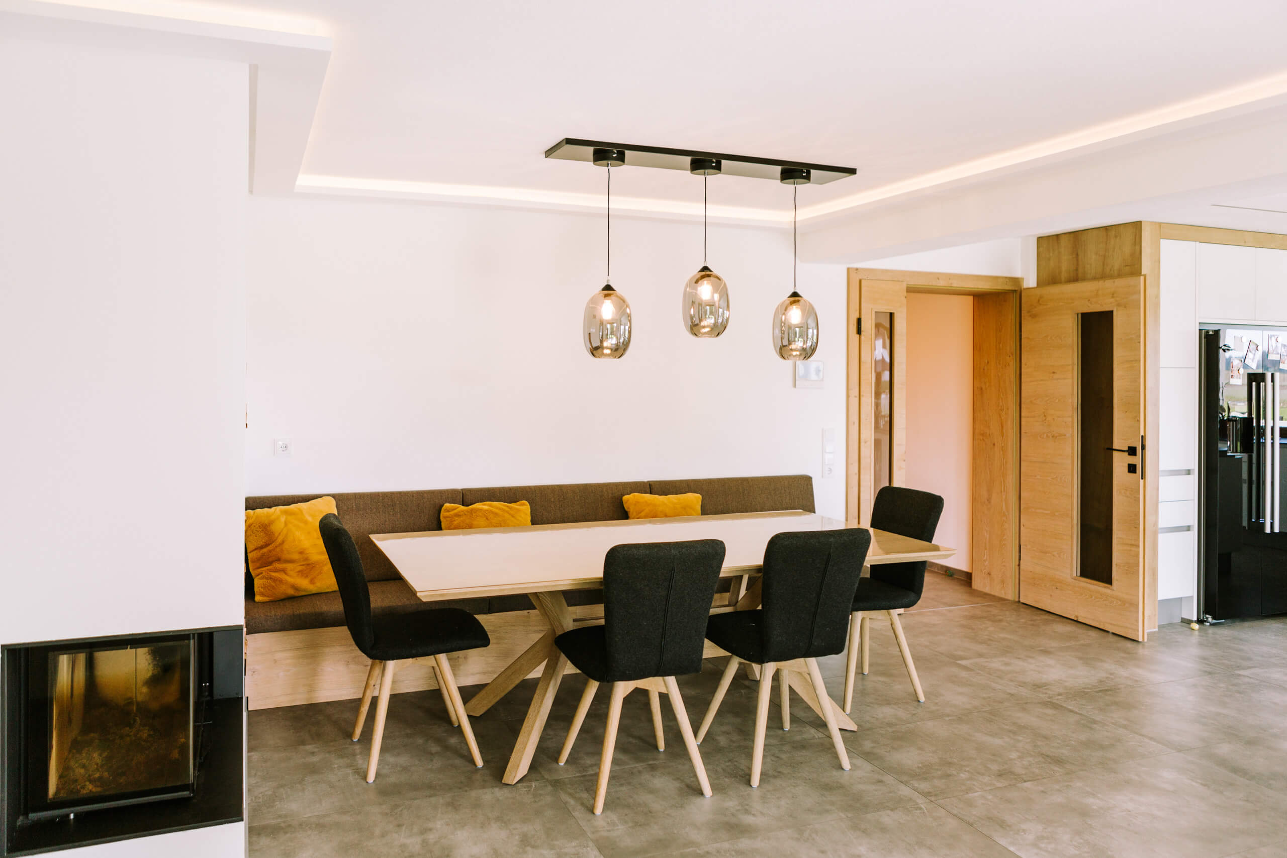 Moderner Essbereich mit Eckbank, Esstisch und Pendelleuchten – Lichtplanung von Illumina.