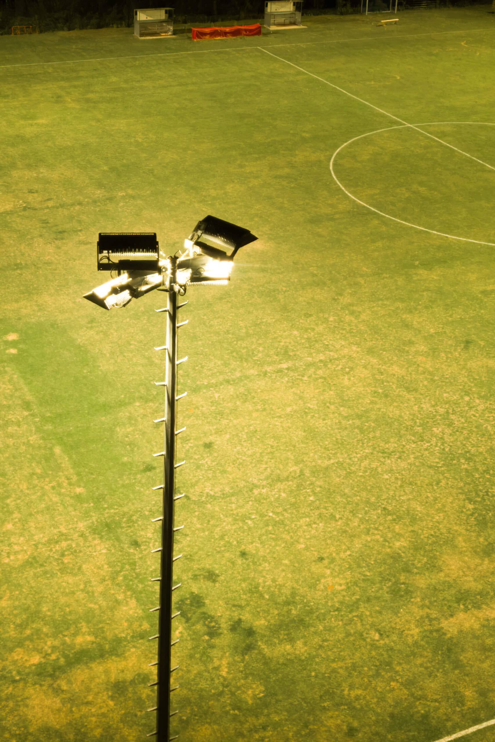 Illumina: Flutlichtmast beleuchtet Fußballplatz bei Nacht.