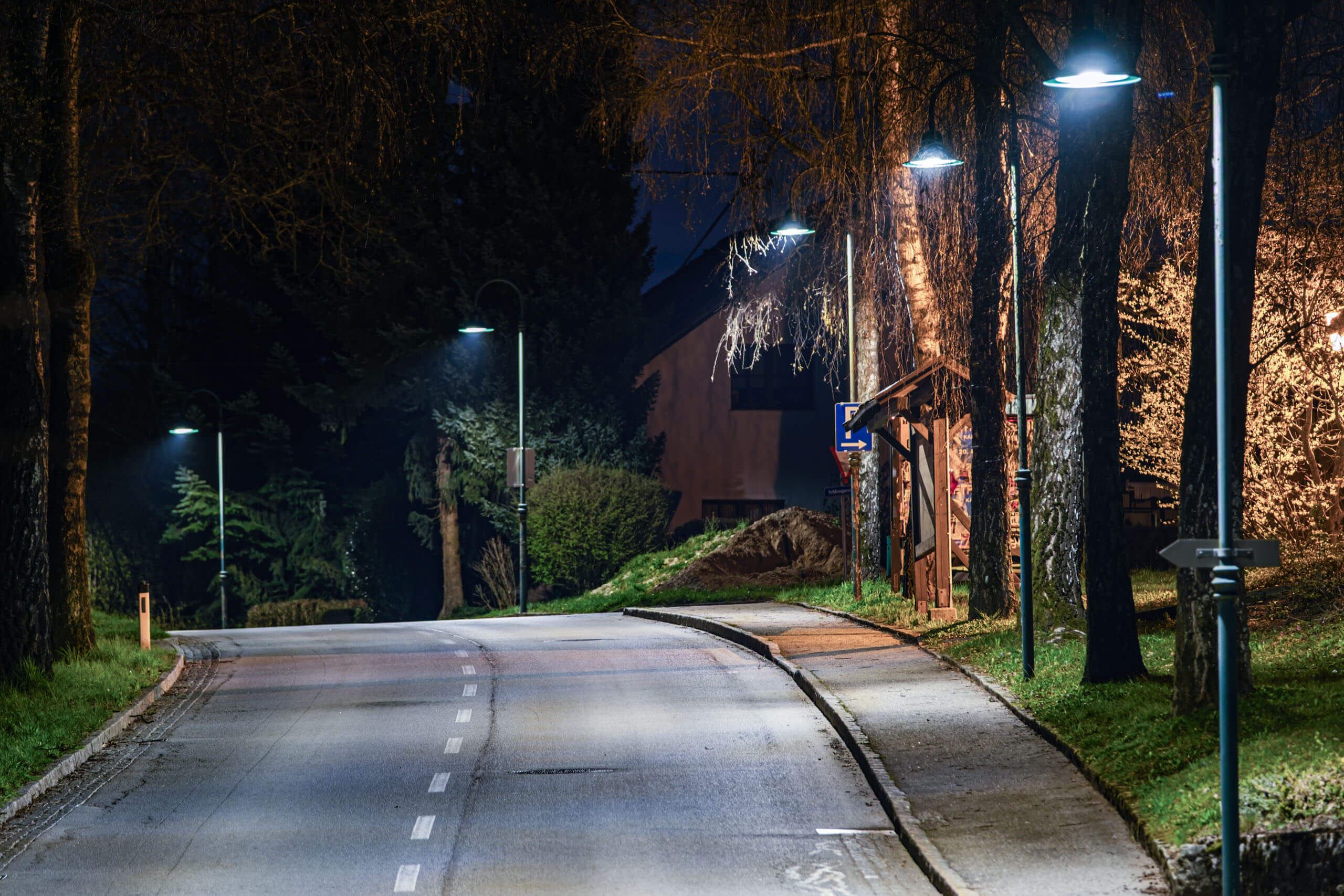 Straßenbeleuchtung in Raab: Eine leere Straße mit Laternen bei Nacht.