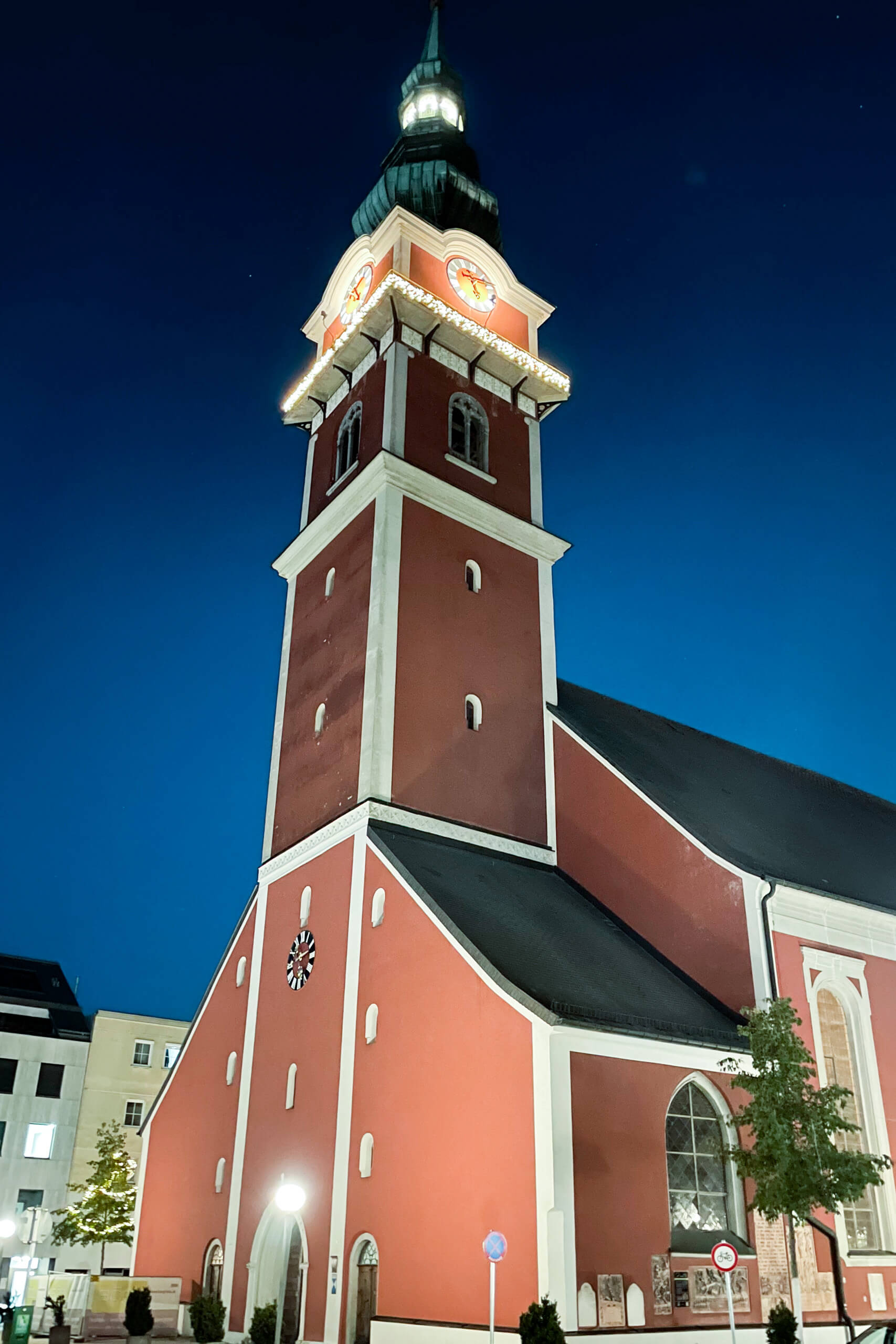 Kirchturm mit beleuchteten Zifferblättern bei Nacht, Architekturbeleuchtung von Illumina
