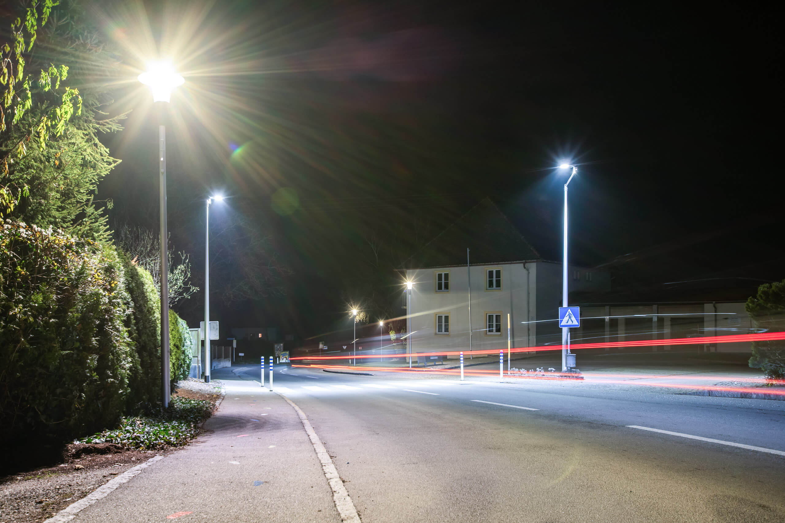 Straßenbeleuchtung mit Lichtspuren von Autos bei Nacht, beleuchtet von Illumina.