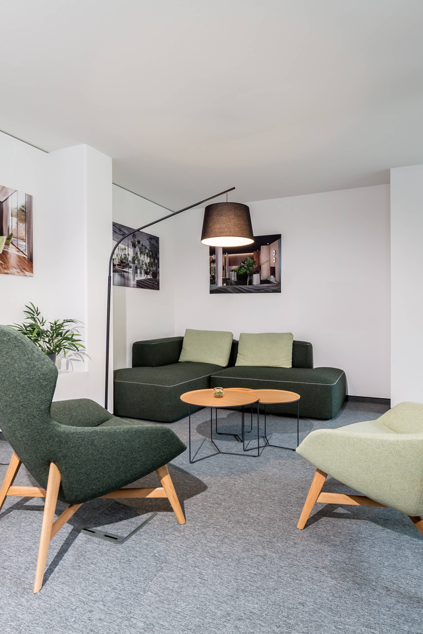 Gemütliche Sitzgruppe mit modernem Sofa und Sesseln, beleuchtet durch eine Stehleuchte