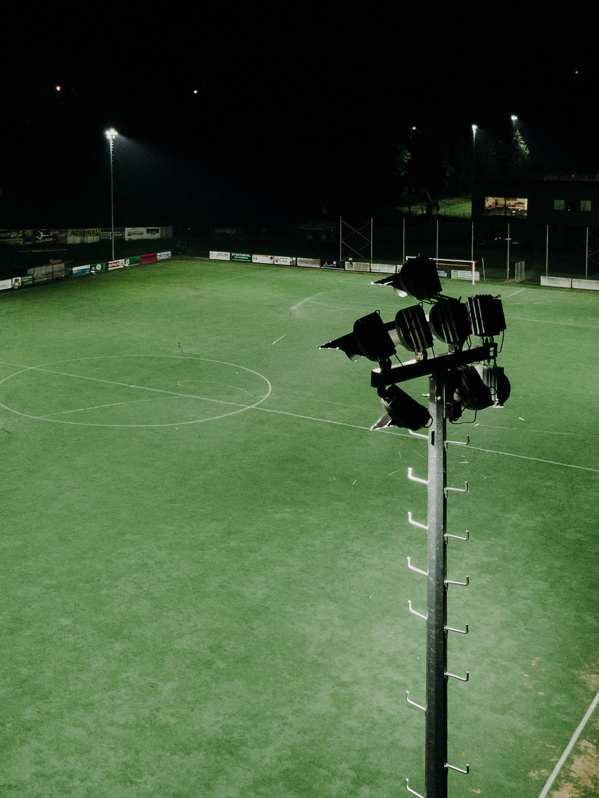 Sportplatzbeleuchtung mit Flutlichtmast im Dunkeln