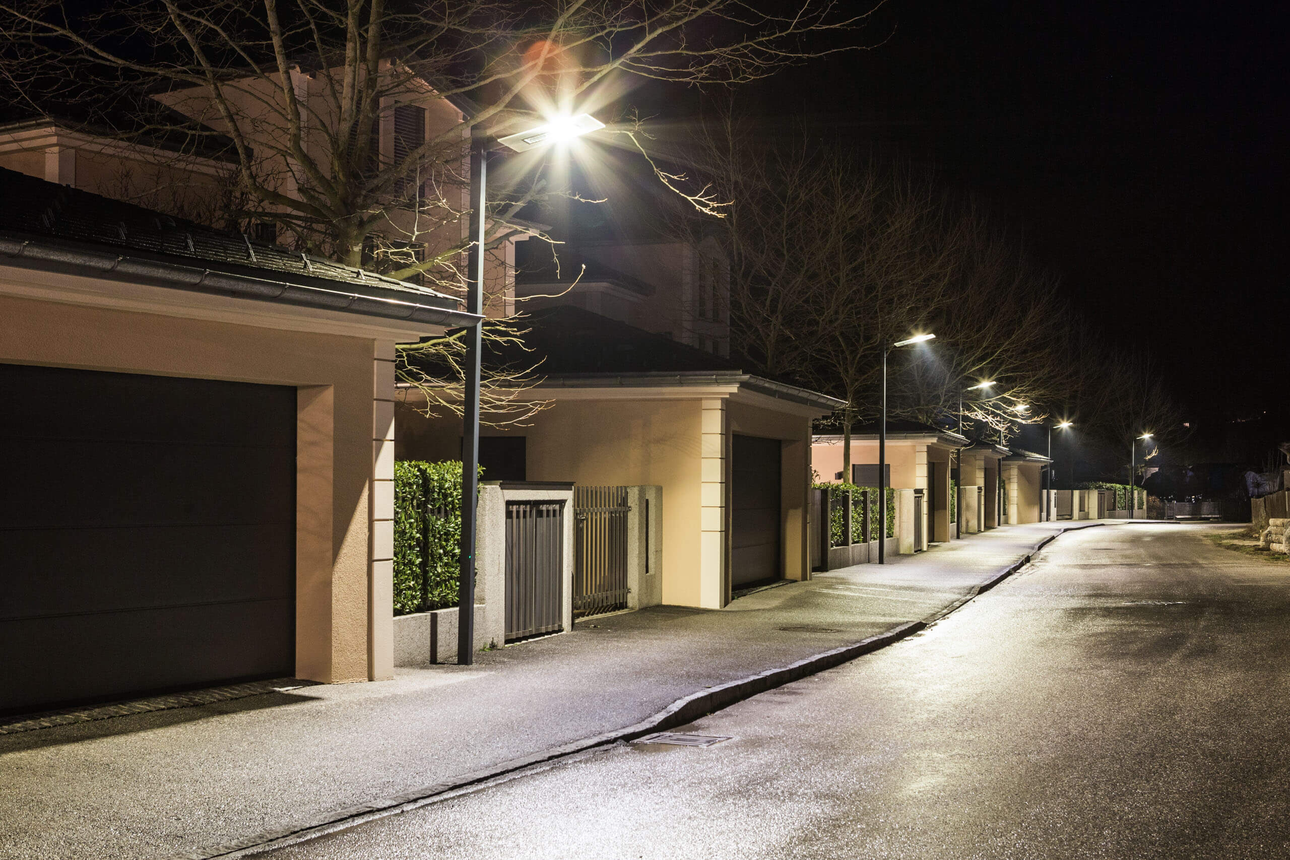 Nächtliche Straßenbeleuchtung mit modernen Laternen entlang einer Wohnstraße