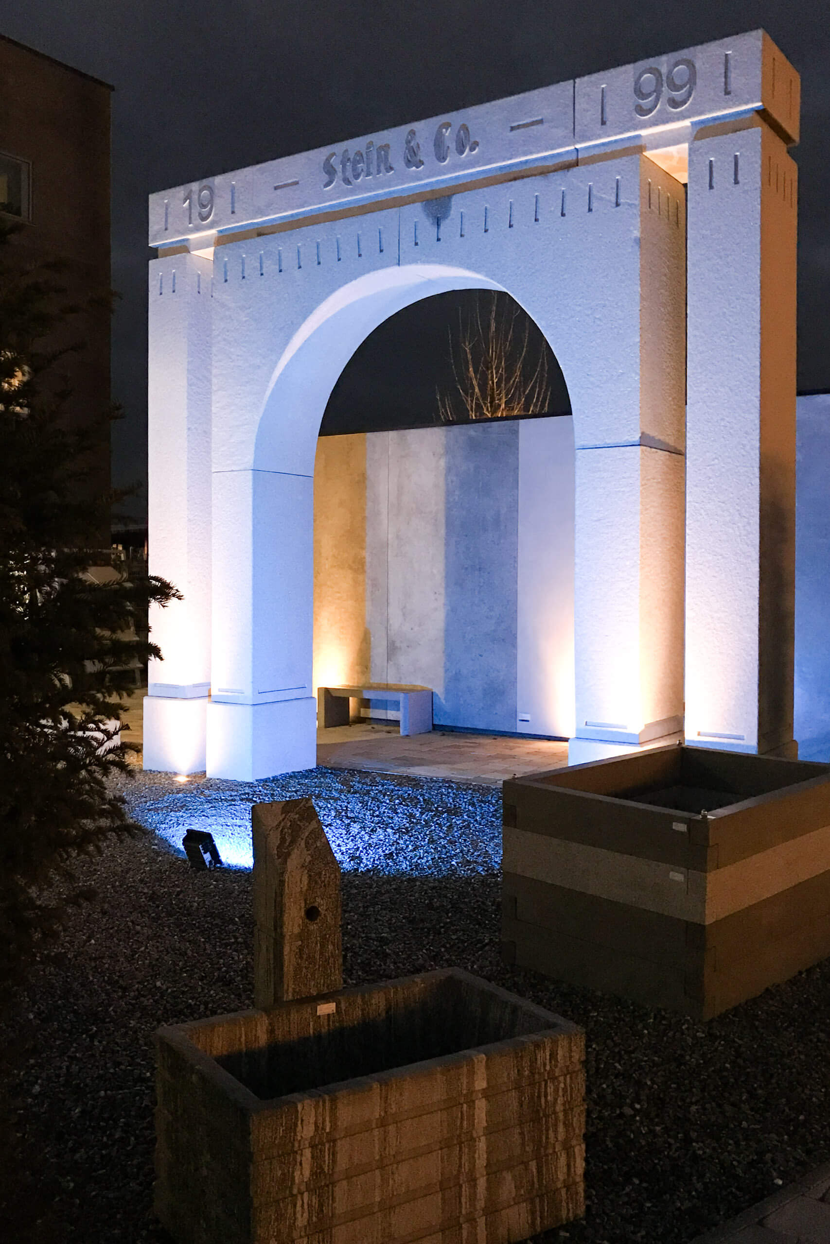Illumina Lichtplanung: Außenbeleuchtung eines steinernen Bogens mit Jahreszahlen 1991.