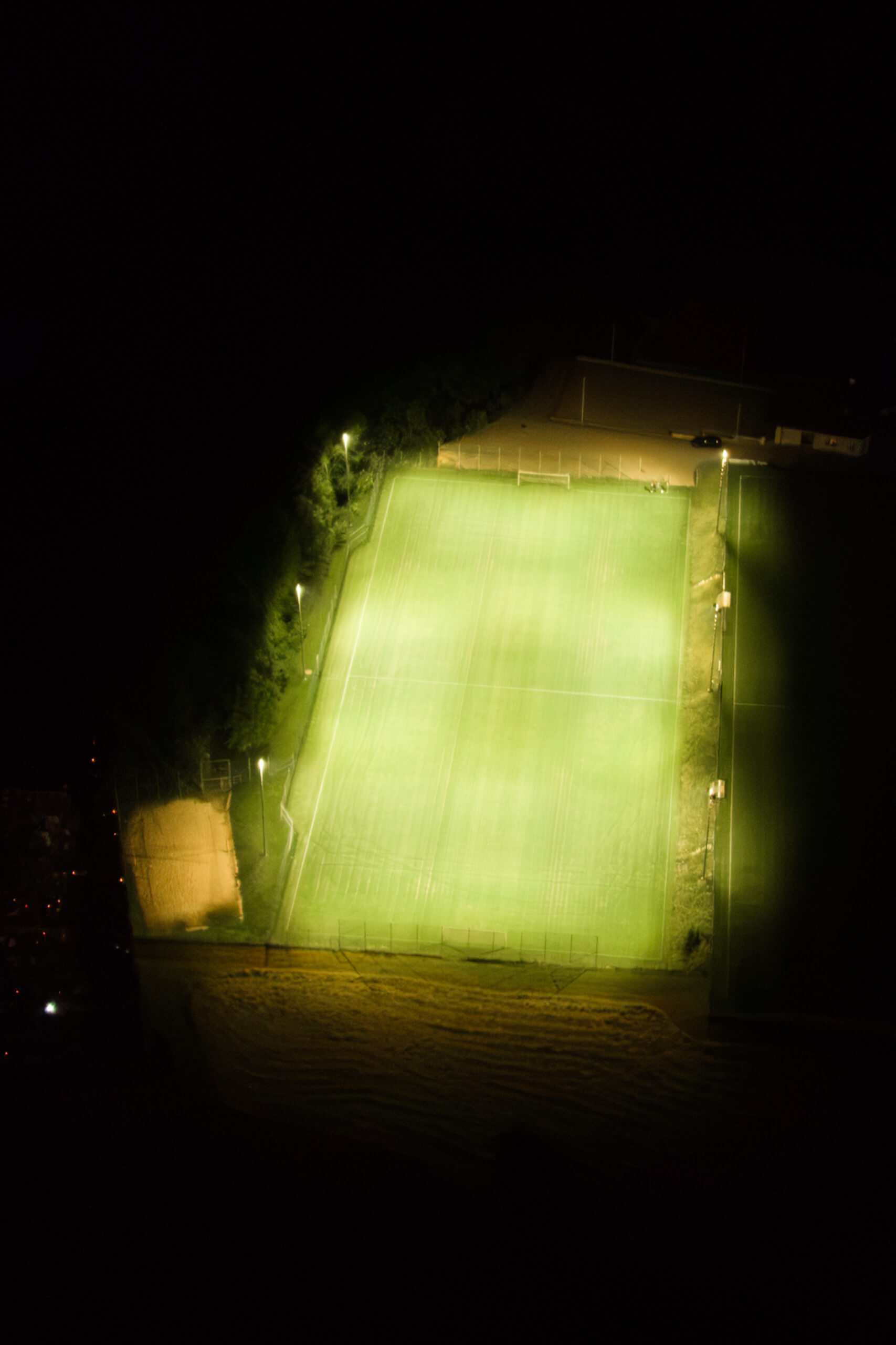 Sportplatzbeleuchtung bei Nacht, gut beleuchtet mit grünem Rasen
