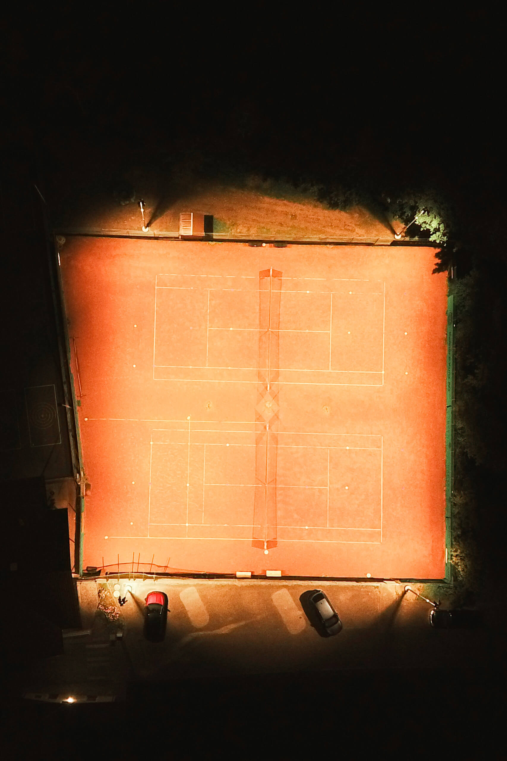 Tennisplatz-Beleuchtung von Illumina: Zwei beleuchtete Sandplätze bei Nacht.