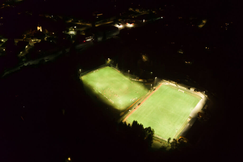 Illumina: Nachtaufnahme von zwei hell erleuchteten Sportplätzen aus der Vogelperspektive