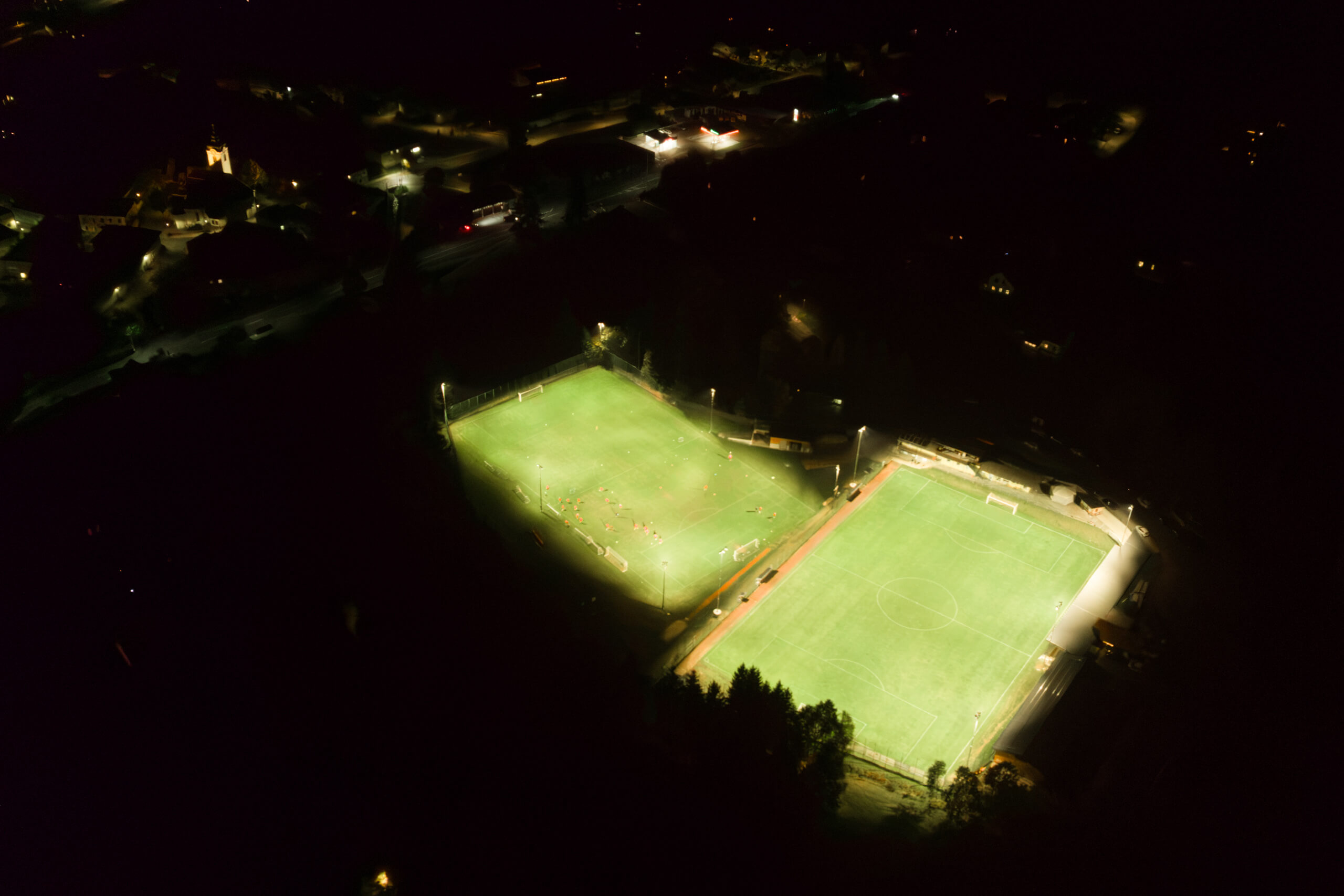 Illumina: Nachtaufnahme von zwei hell erleuchteten Sportplätzen aus der Vogelperspektive