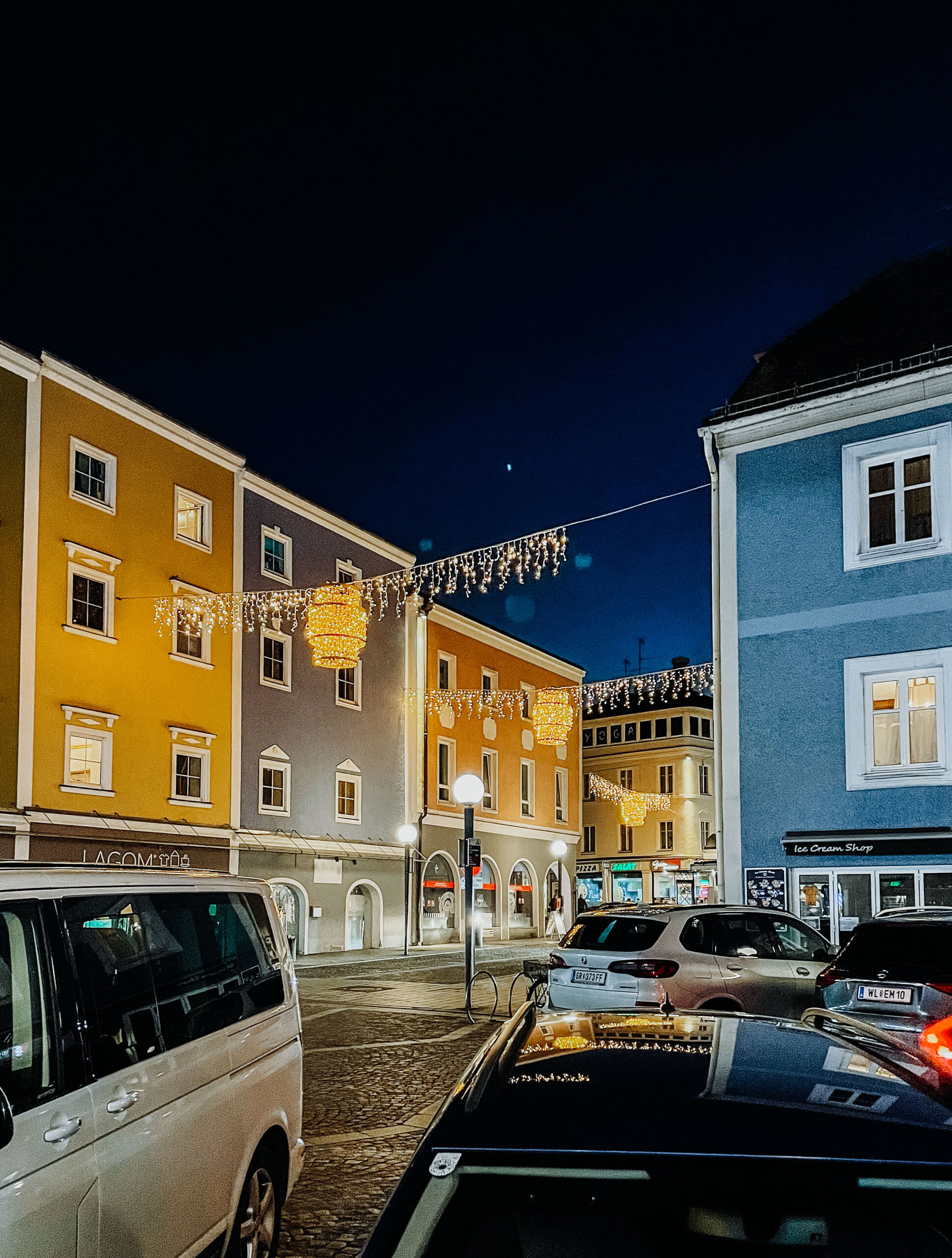 Weihnachtsbeleuchtung in einer Gemeinde mit bunten Häusern und Autos