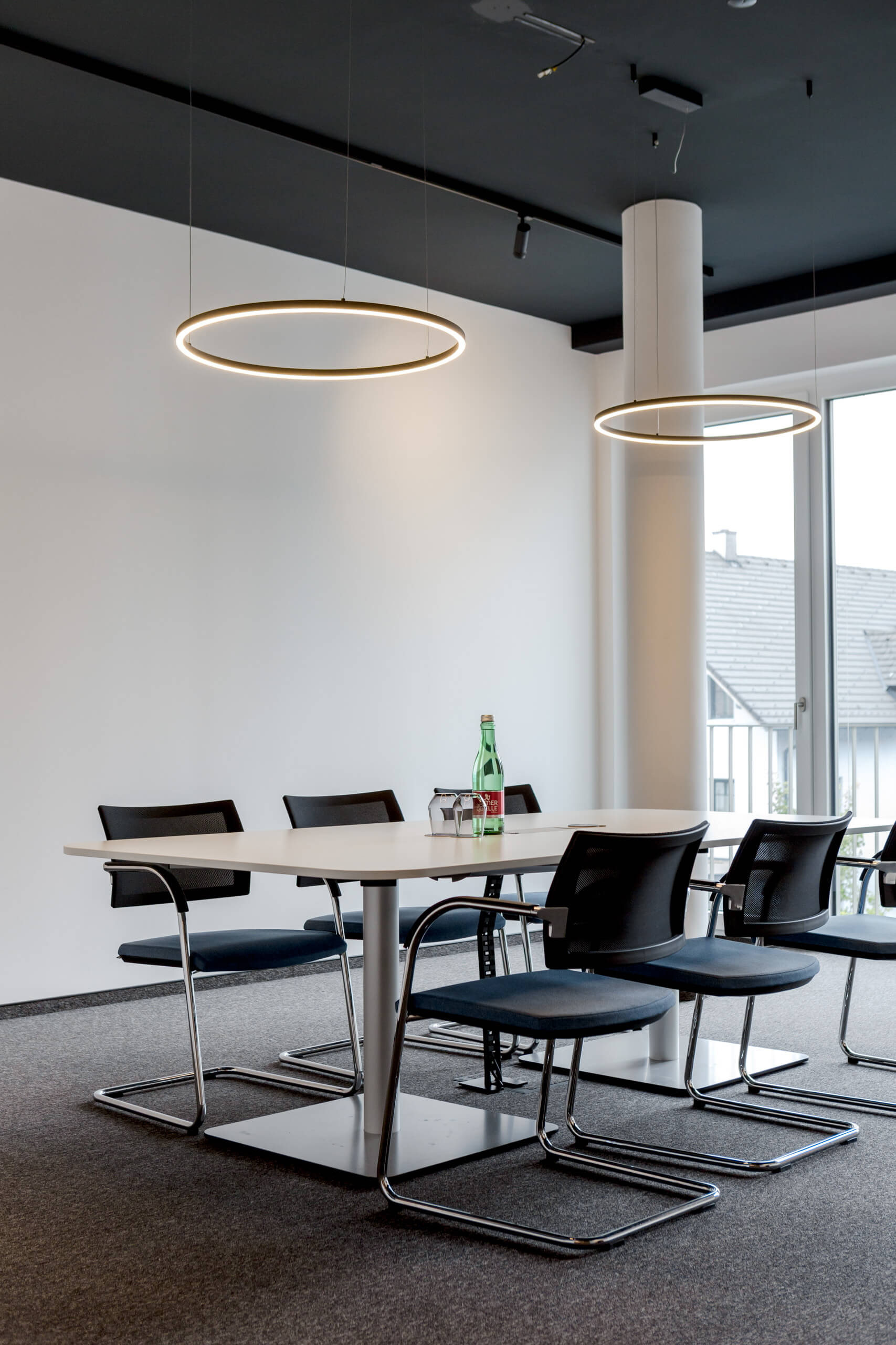 Modernes Büro mit Konferenztisch und stilvollen Hängeleuchten