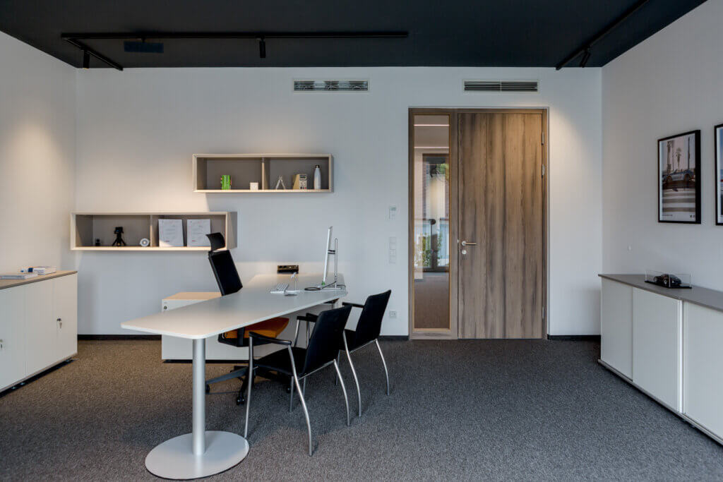 Modernes Büro mit Schreibtisch und Tür – Lichtplanung von Illumina.